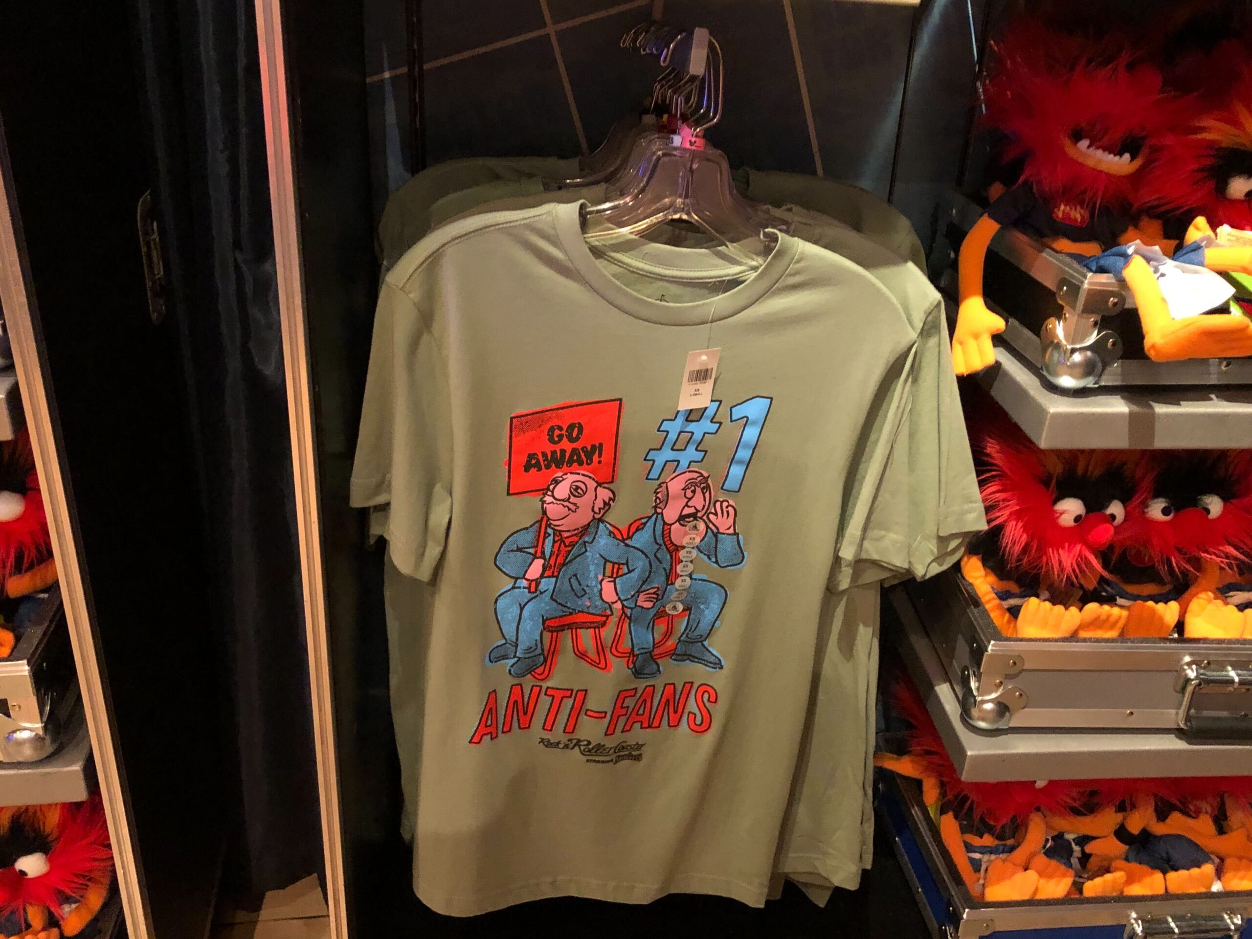 Statler and Waldorf are on this sage green shirt. Waldorf is holding a GO AWAY! sign with the text on the shirt reading #1 ANTI-FANS.