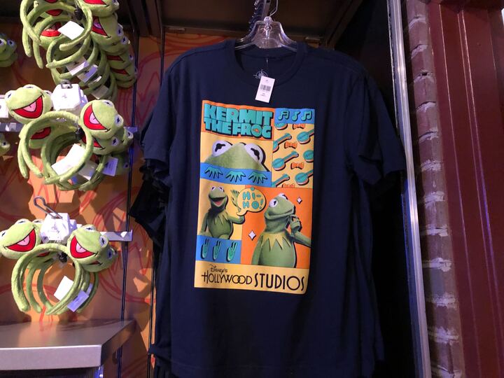 Kermit is on this blue shirt with three different images of him, his banjos, and a word bubble that reads Hi-Ho!