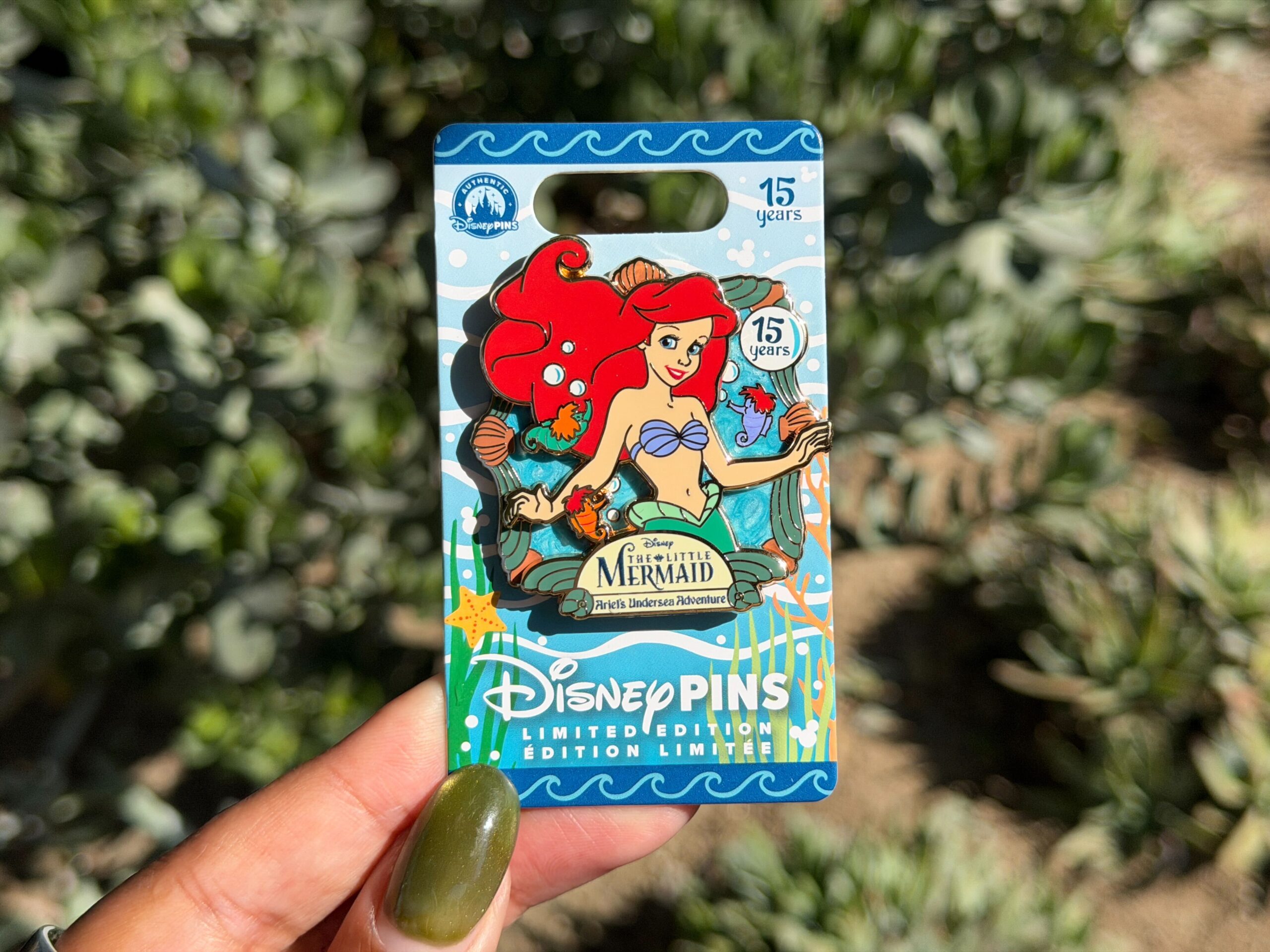Similarly, a pin was also released for the 15th anniversary of Ariel's Undersea Adventure. The pin shows the attraction name along with a large image of Ariel with three little seahorses swimming around her.