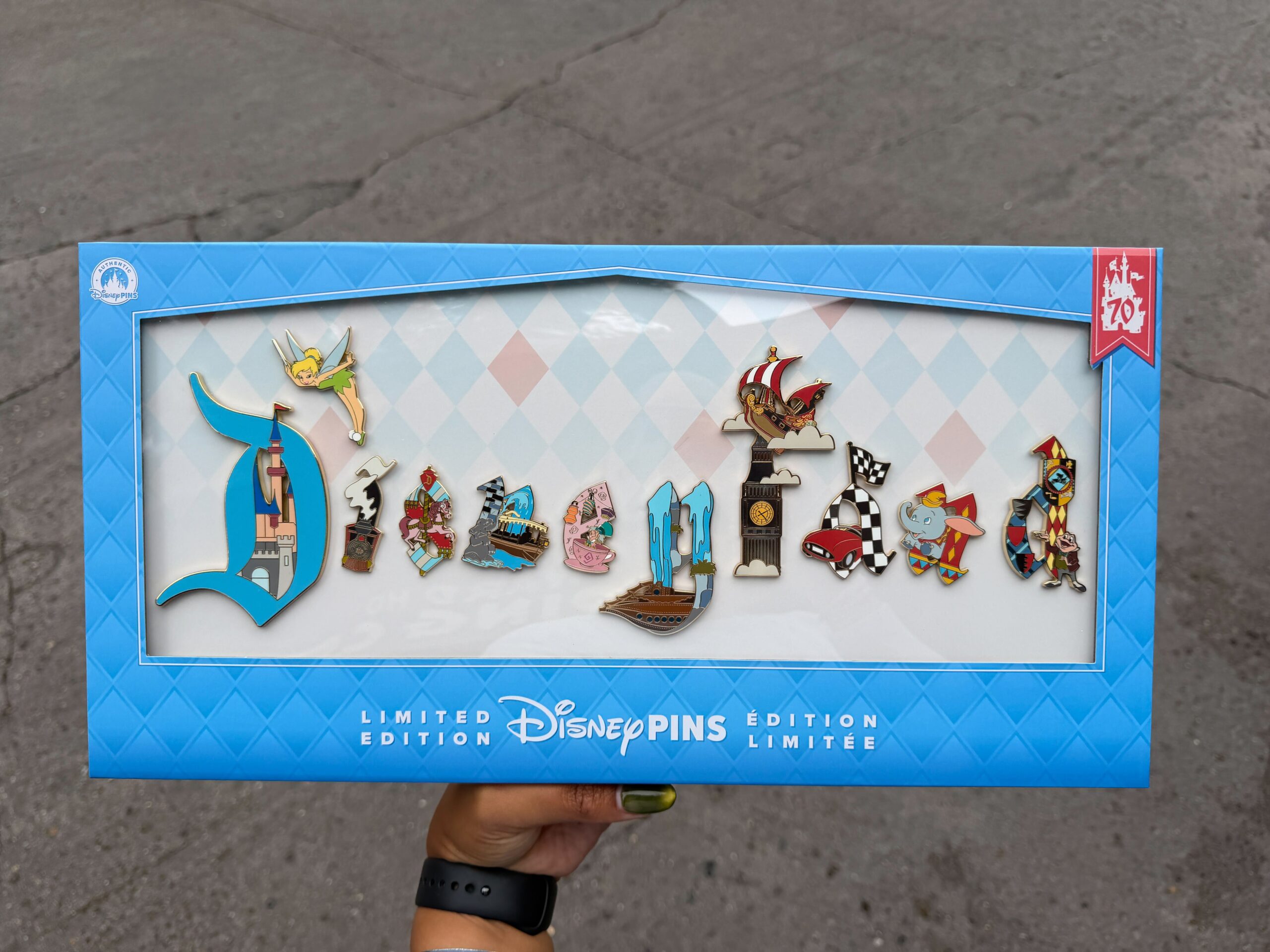 This limited edition pin set comprises 11 pins. One is an independent Tinker Bell flying, while every other pin is a letter that spells out "Disneyland" when they are all put together. Each letter comprises something different from the park. For instance, the "D" has Sleeping Beauty Castle inside it, the "e" shows the Mad Tea Party, and the second "n" is Dumbo the Flying Elephant.