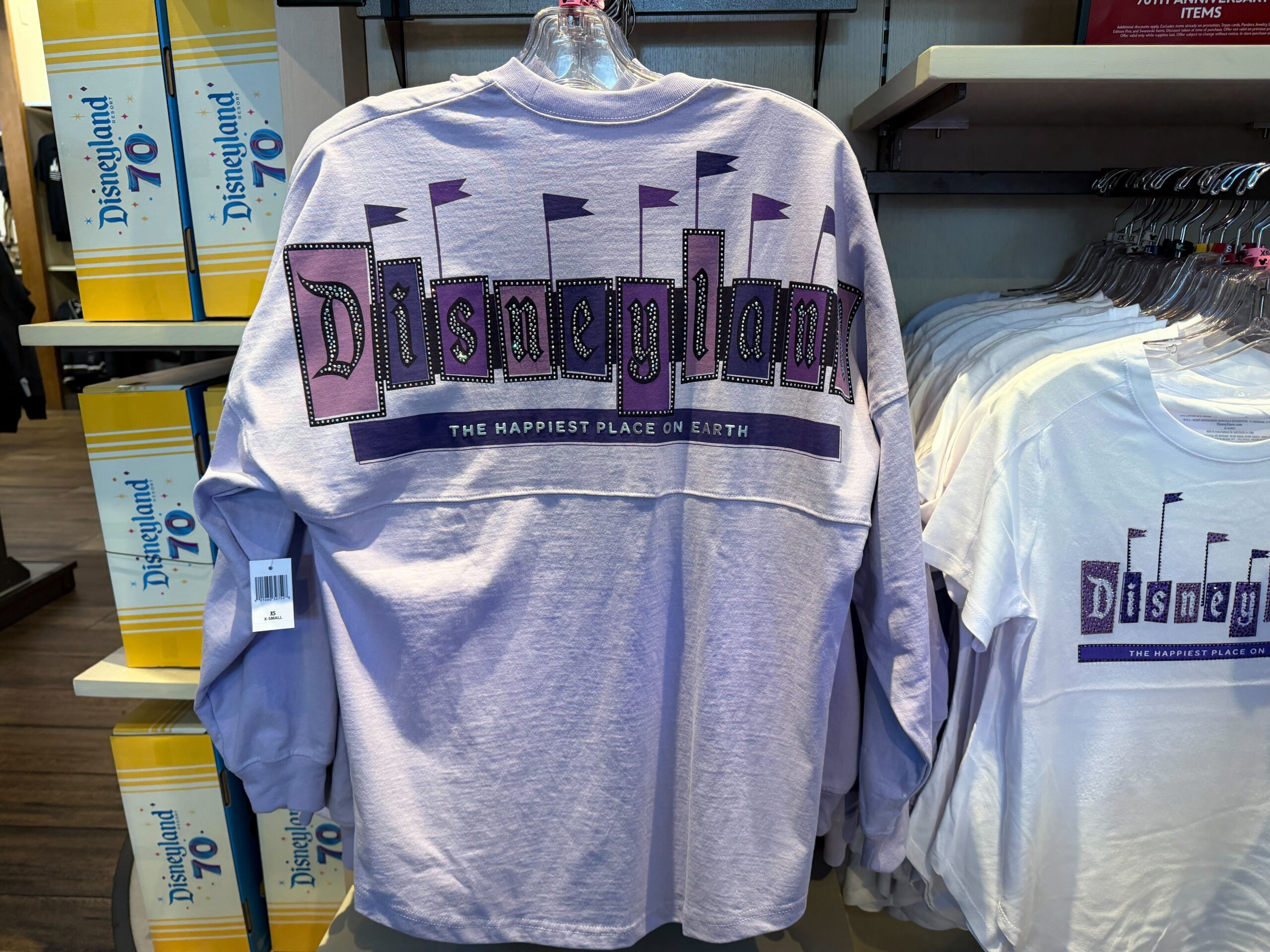 This light purple jersey features the Disneyland 70 logo on the left chest. Silver puffy ink and rhinestone accents highlight the logo.