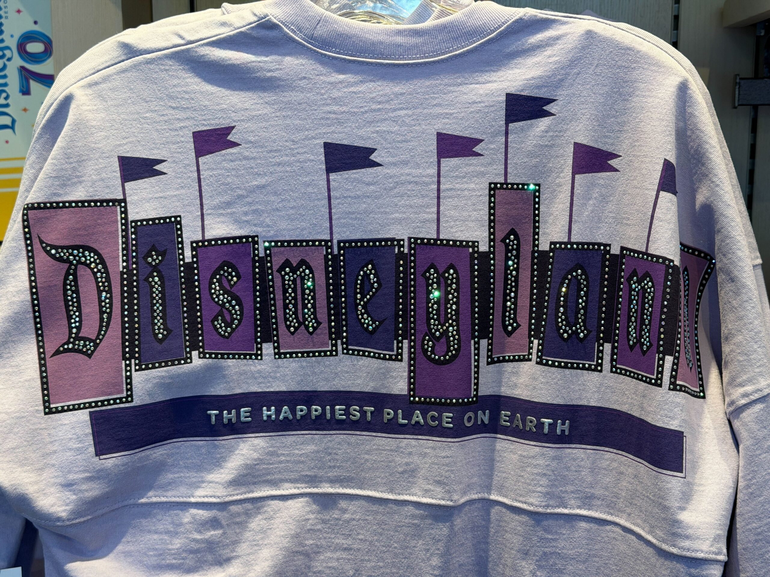 This light purple jersey features the Disneyland 70 logo on the left chest. Silver puffy ink and rhinestone accents highlight the logo.