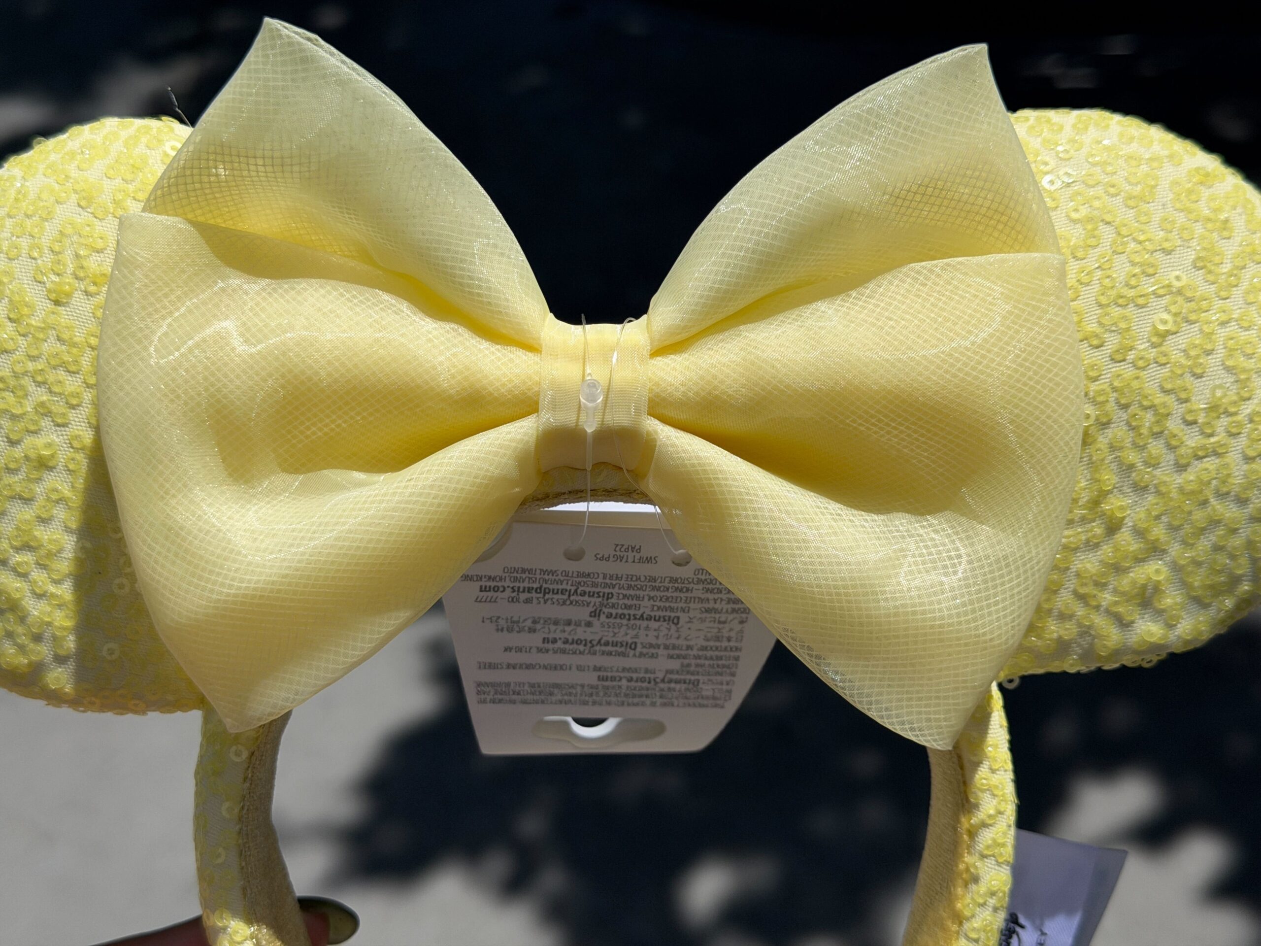 The ear headband is a similar butter yellow color with sequins covering the ears and headband.