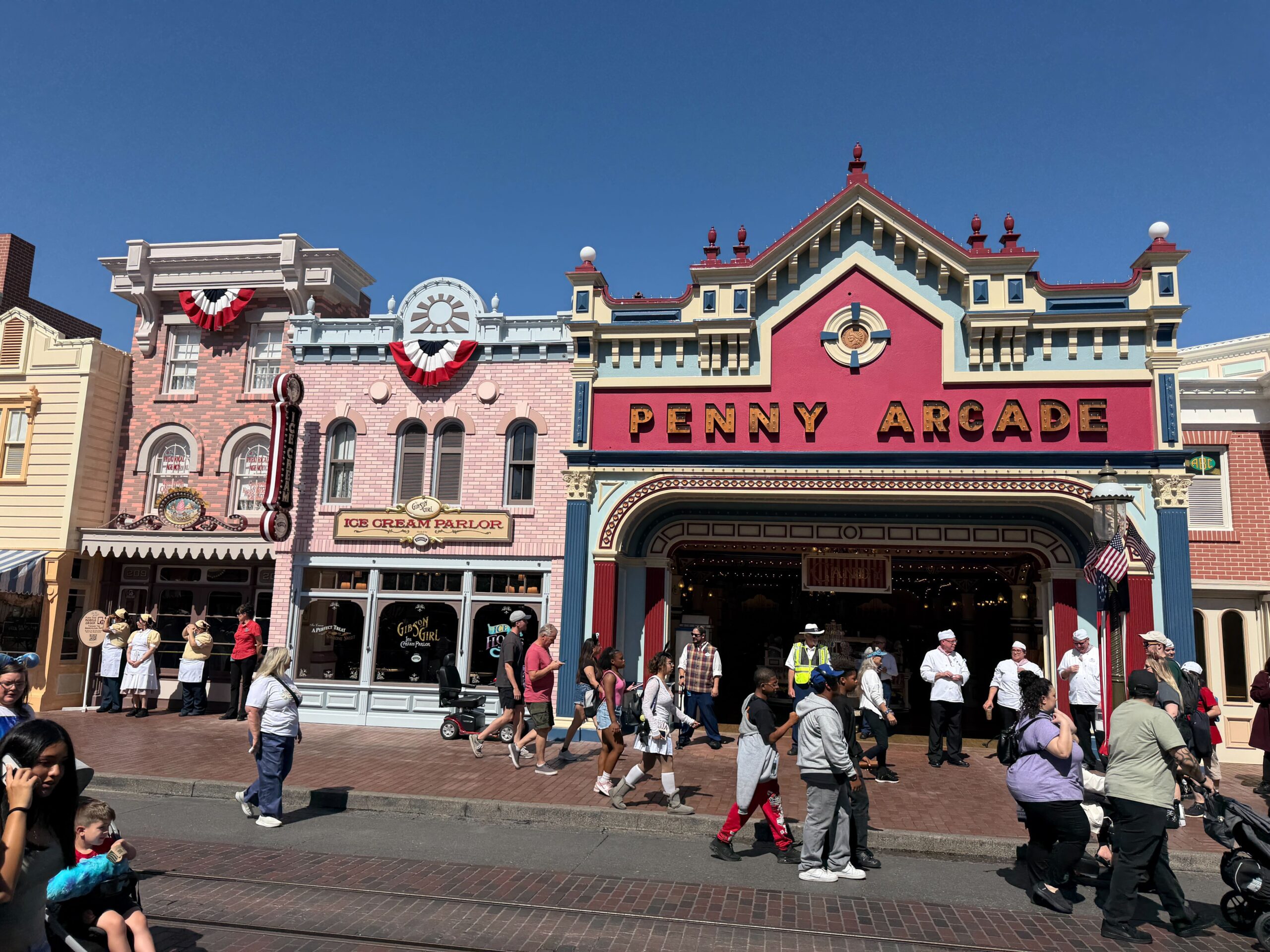 City Hall, the Emporium, and more facades are adorned with red, white, and blue bunting. They hang from roofs and balconies.