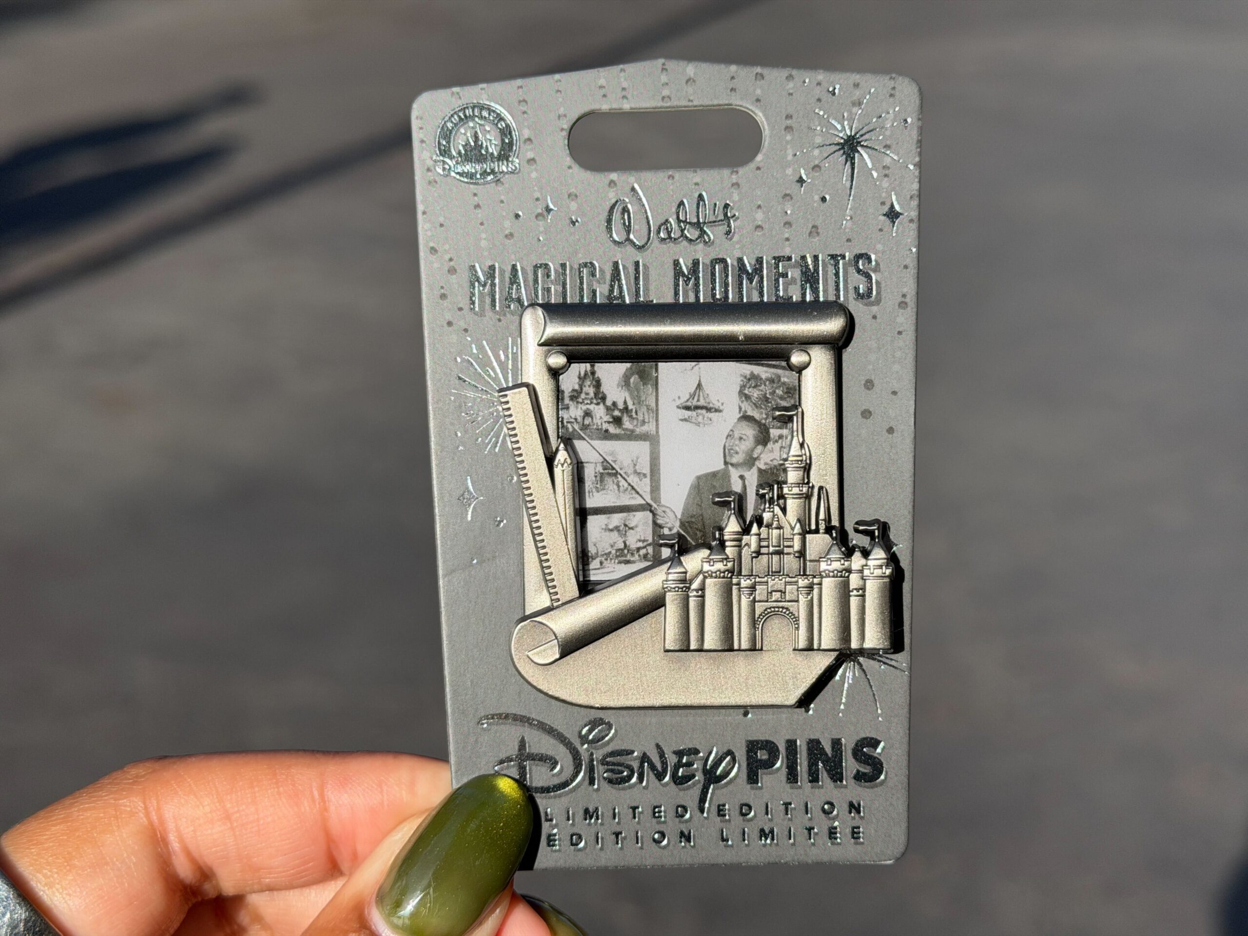 The fifth "Walt's Magical Moments" pin is inspired by Sleeping Beauty Castle. It features a black-and-white photo of Walt Disney pointing at artwork of the castle. The pewter frame around the photo includes a sculpted depiction of Sleeping Beauty Castle.