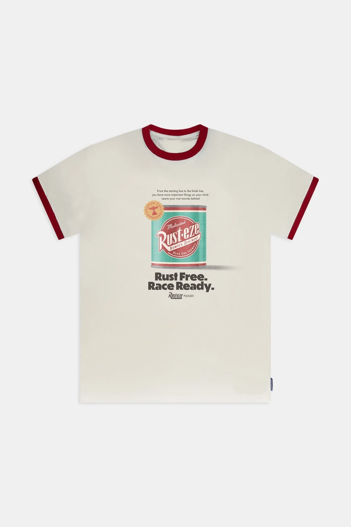 This white ringer tee has red sleeve hems and rounded collar. On the front of the shirt is a can of Rust-eze Bumper Ointment. Above it are the words "From the starting line to the finish line, you have more important things on your mind. Leave your rust worries behind." in black text. Beneath the can in larger letters is "Rust Free." and "Race Ready." with a small "Rust-eze Please!" at the bottom.