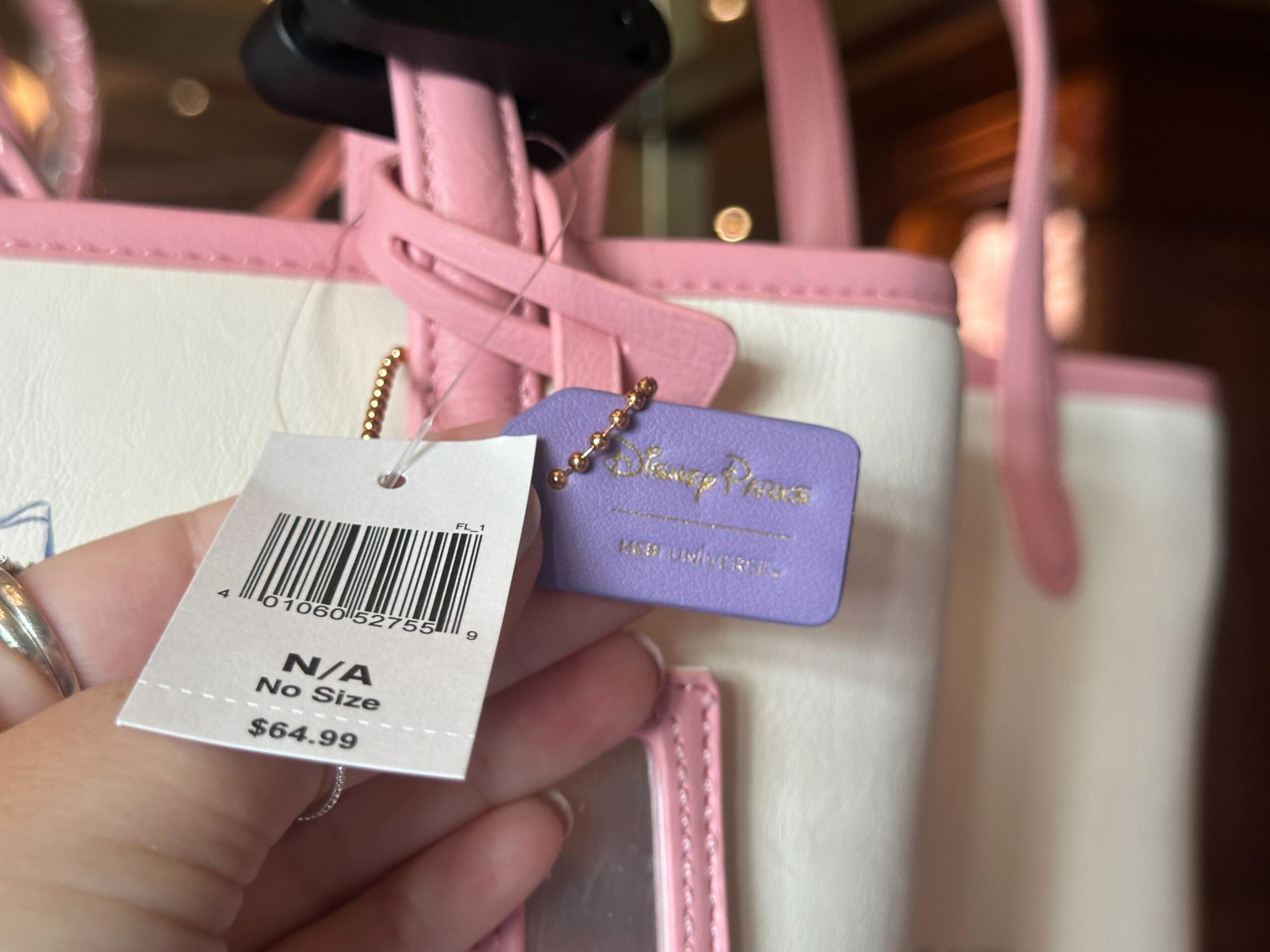 There is a retro hangtag attached to the front strap with Mickey in black and white with the Disney World wordmark and the words "Welcome to Walt Disney World the Most Magical Place on Earth." Another hangtag, this one purple, is also attached with a Disney Parks wordmark.