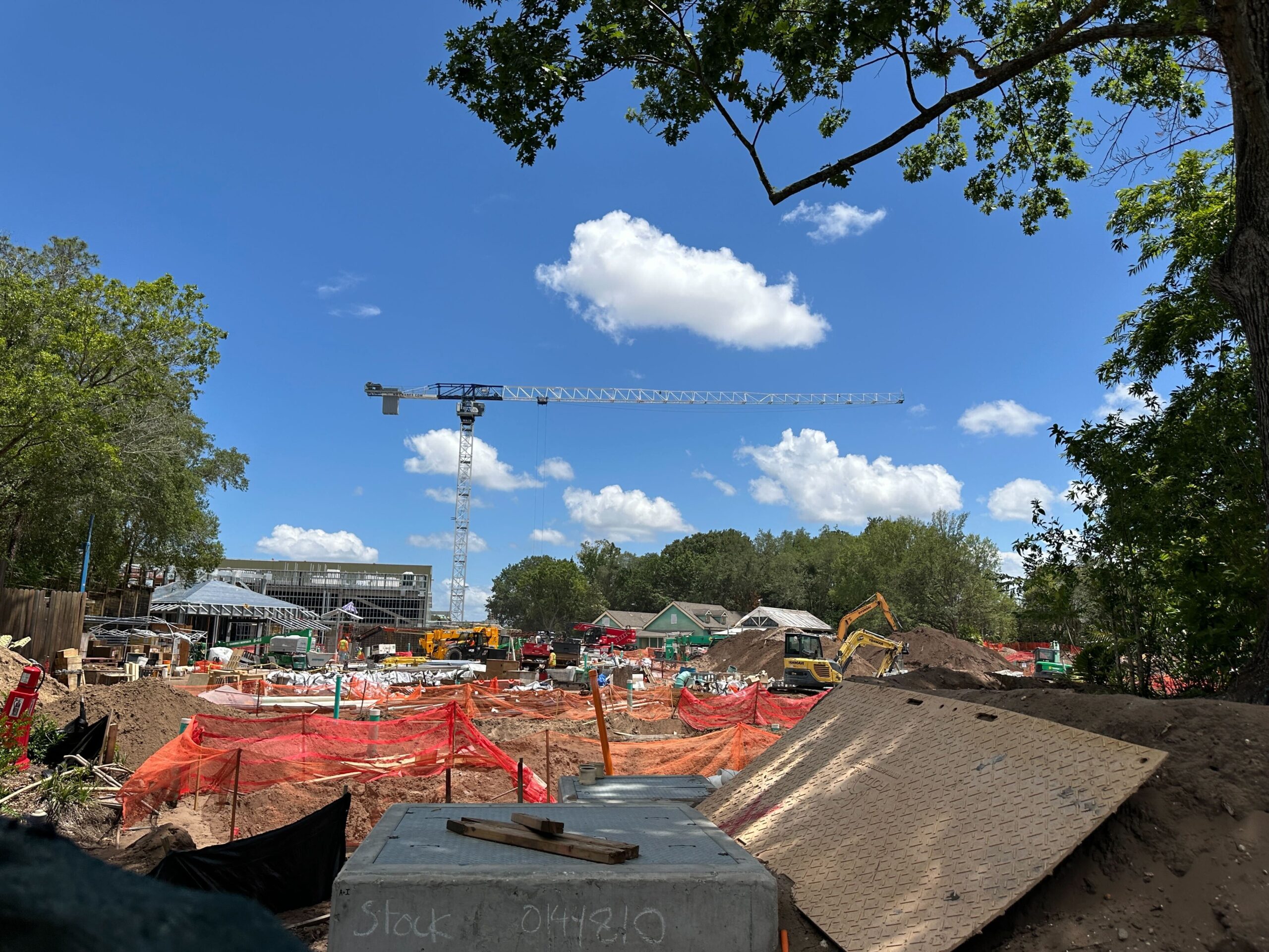 Another view of the area shows the tower crane and the large piles of dirt being created by excavators.