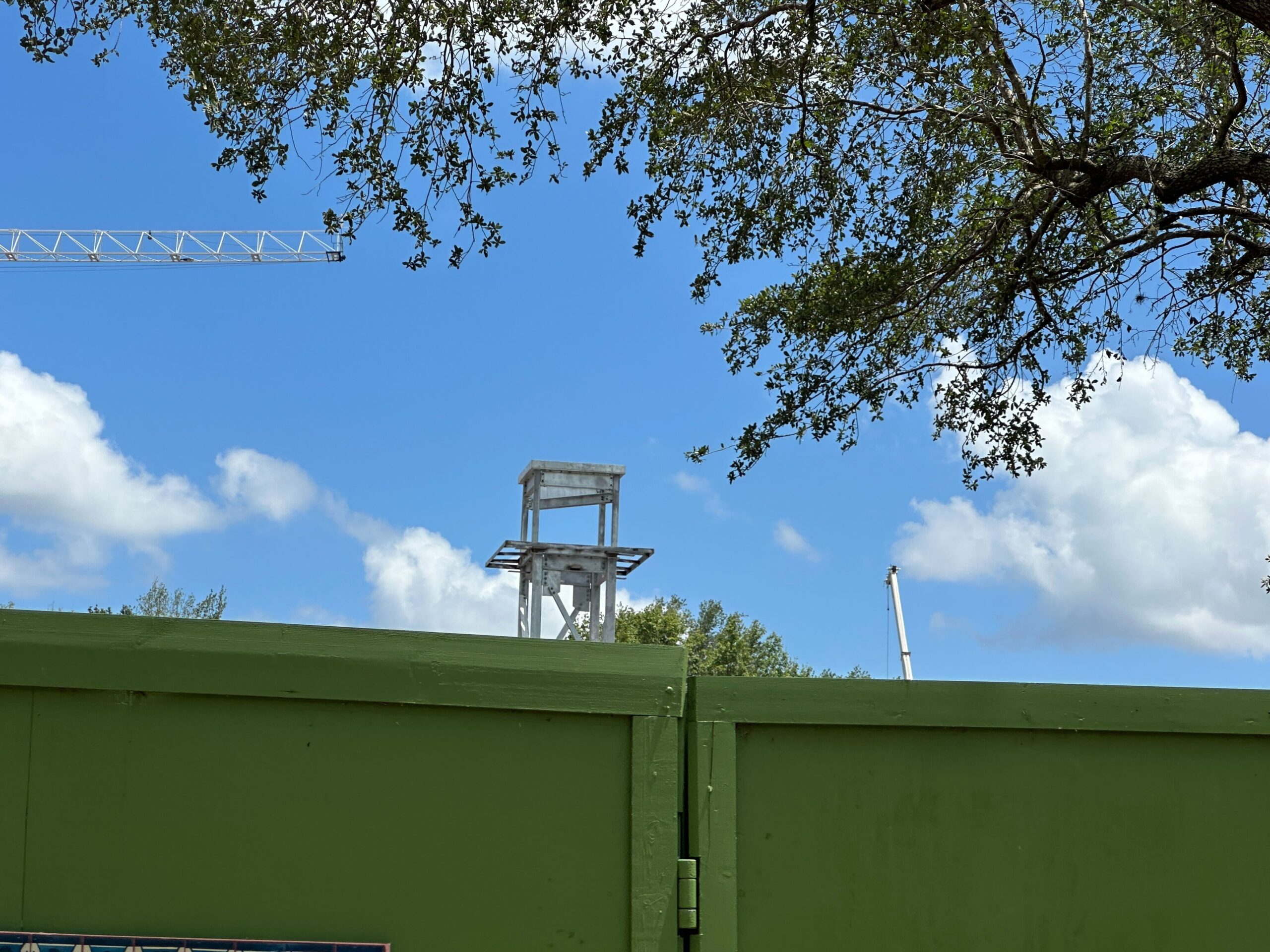 The clock tower that started to go vertical last month is still visible above the green construction walls and is surrounded by cinder block walls.