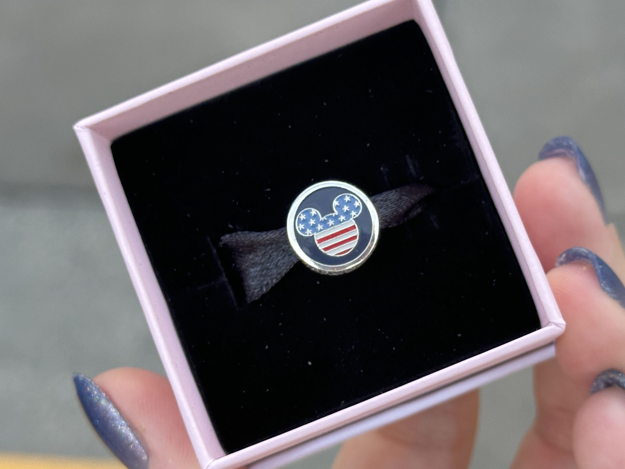 One side of the blue Pandora charm has a Mickey icon with stars on the top half and red and white stripes on the bottom half. On the other side is a star with "Happy 250th" text in front of it.
