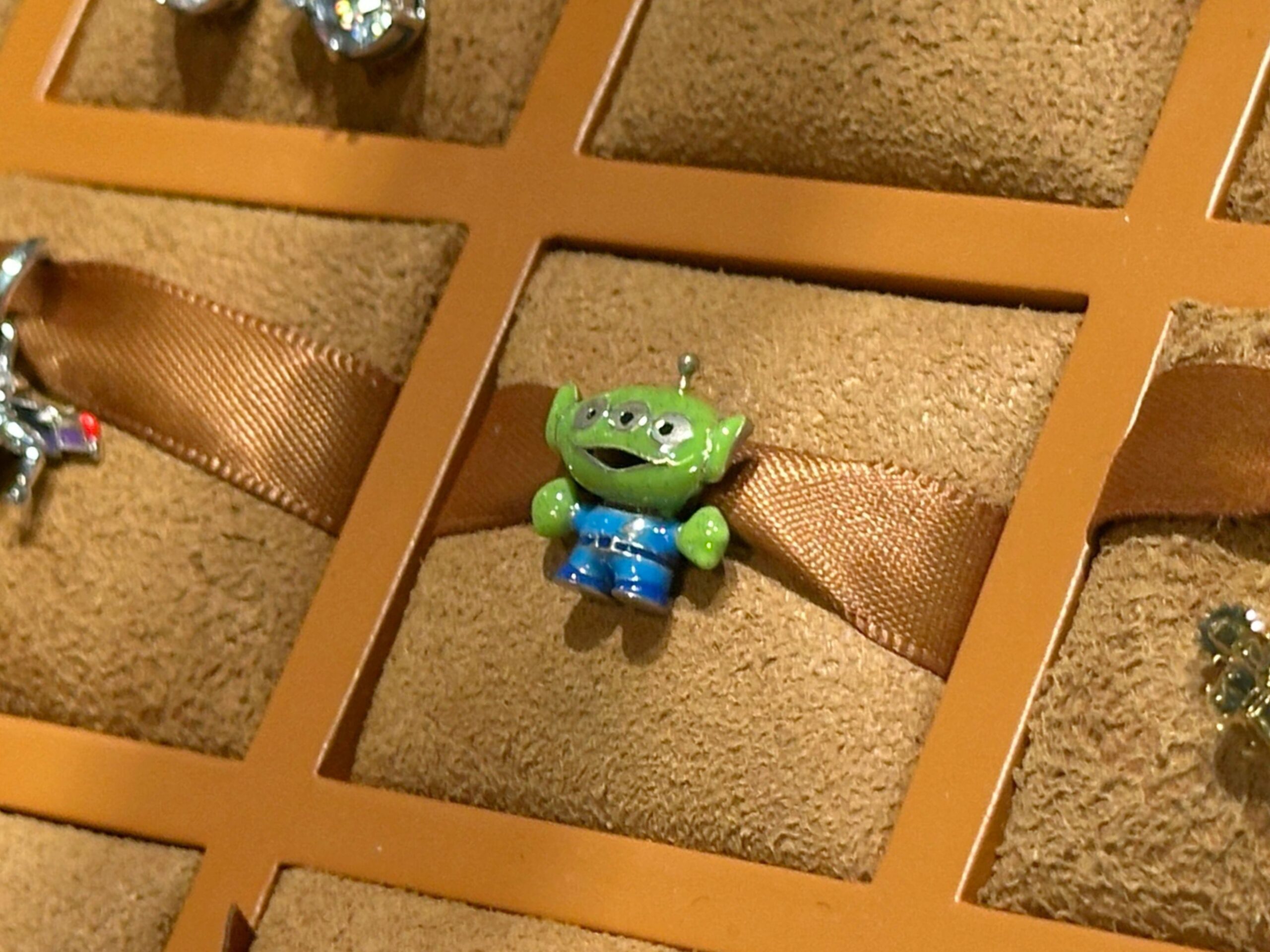 This enamel and sterling silver charm depicts a green alien wearing his blue spacesuit. He has sparkly details.