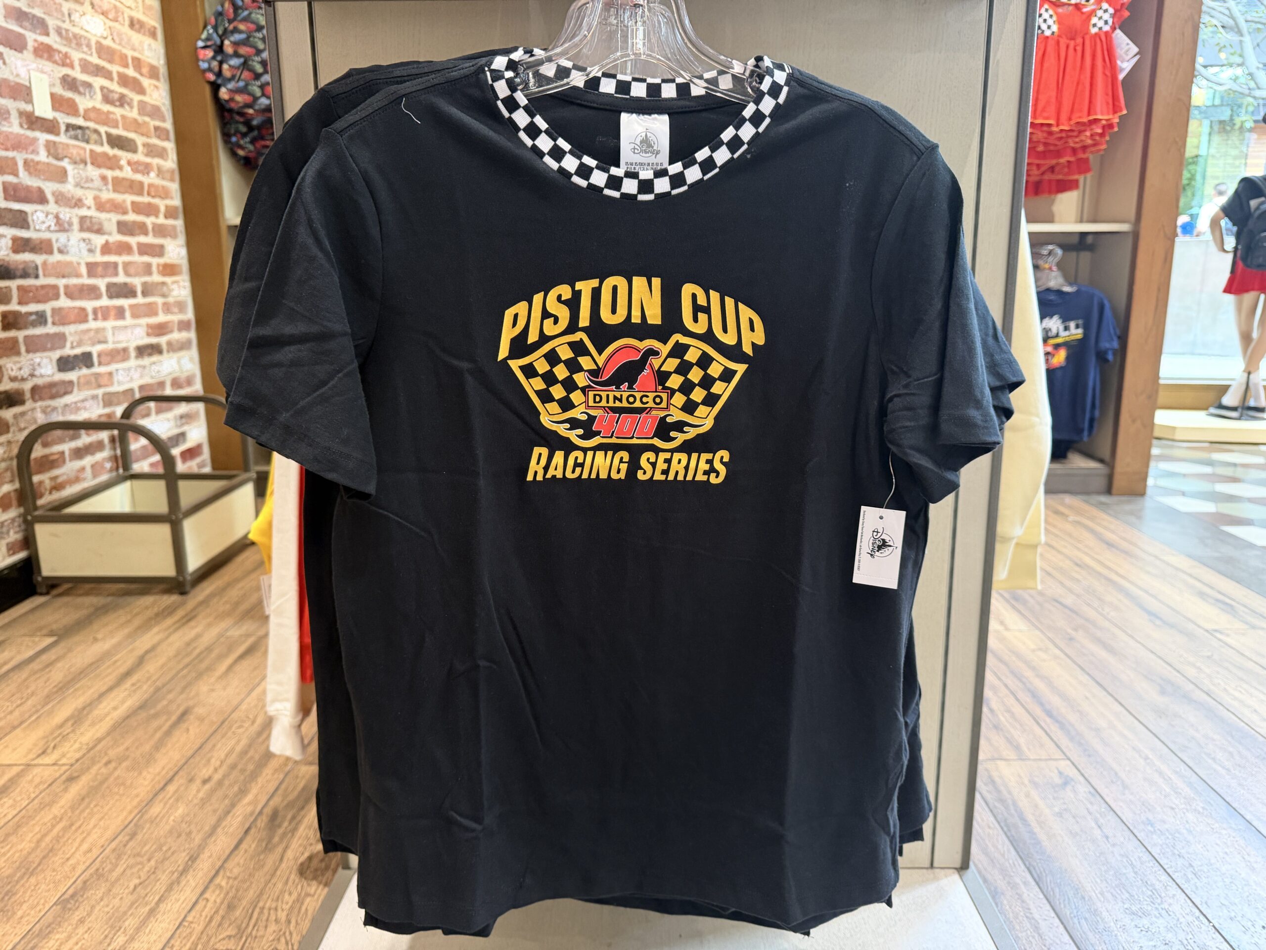 With the same imagery as the hat above, but in yellow rather than white, this black t-shirt is also all about the Piston Cup. The neck is a black and white checkered pattern.