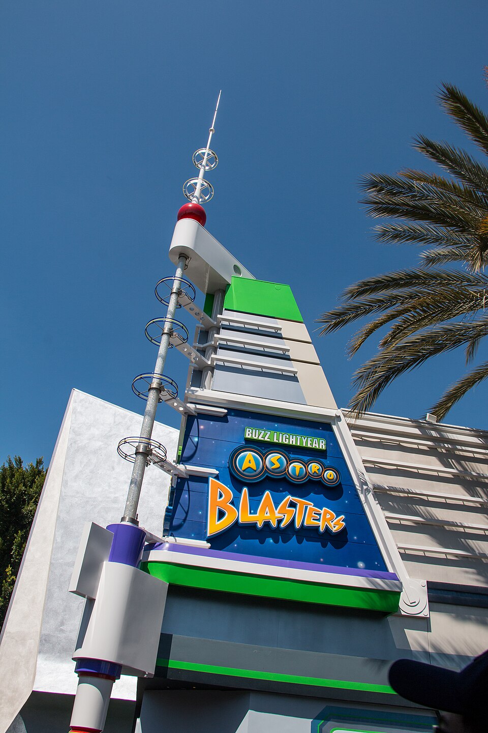 Before the ongoing refurbishment work, the same area used a heavier mix of gray, white, green, purple, and red, pictured above. This range of colors fell more in line with Buzz Lightyear's specific character design and less so any overarching color palette used throughout Tomorrowland.