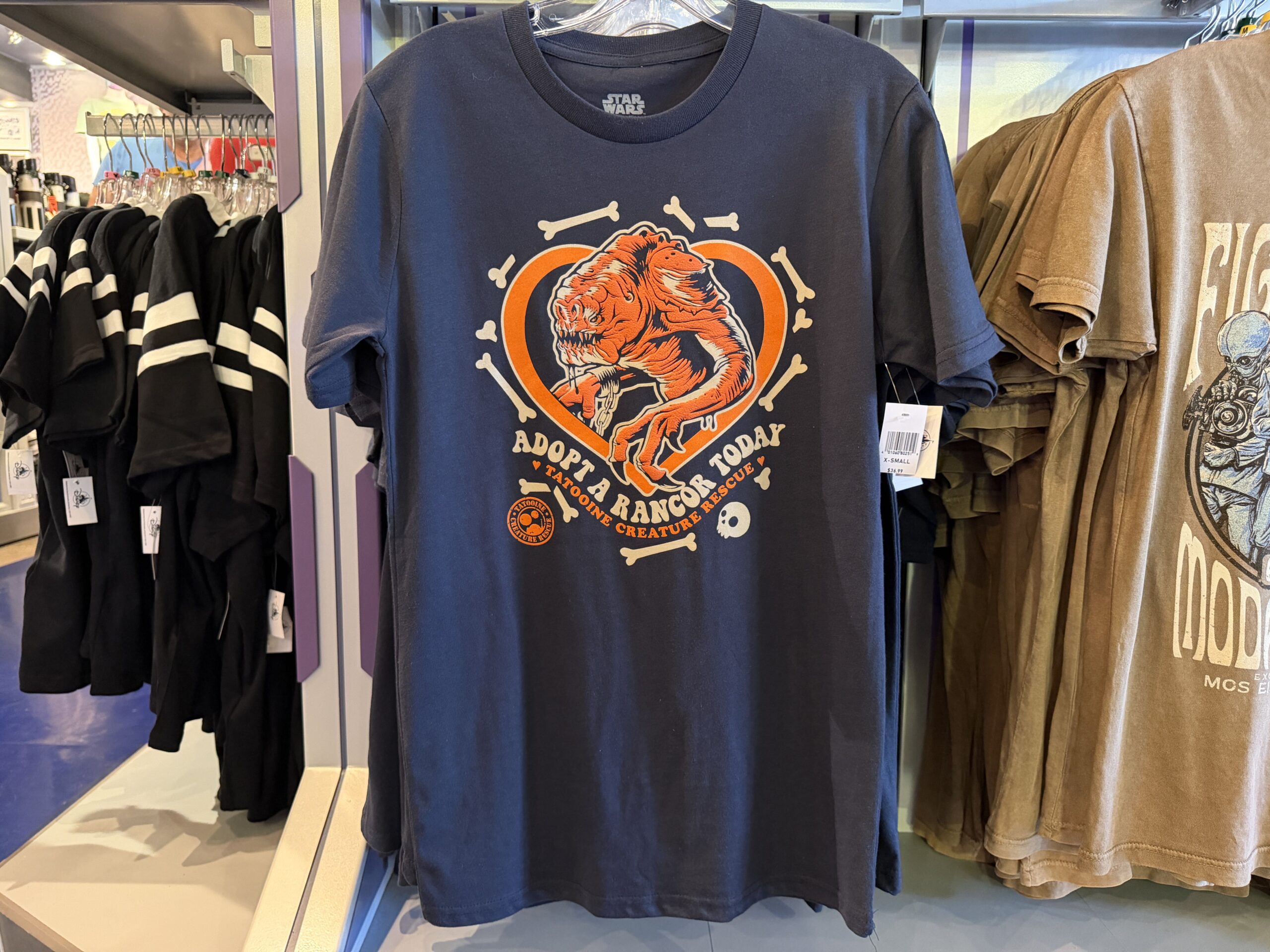 A new wave of Star Wars merchandise has arrived at Disneyland, including several graphic T-shirts, a keychain, and multiple Hasbro Black Series figures inspired by Star Wars: Attack of the Clones, The Mandalorian & Grogu, Star Tours, and more.