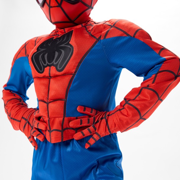 The top features faux muscle padding across the chest, shoulders, and stomach, with Spidey’s black spider emblem on the front. The red-and-blue design includes webbing throughout the arms and upper body, plus red webbed panels on the lower legs.