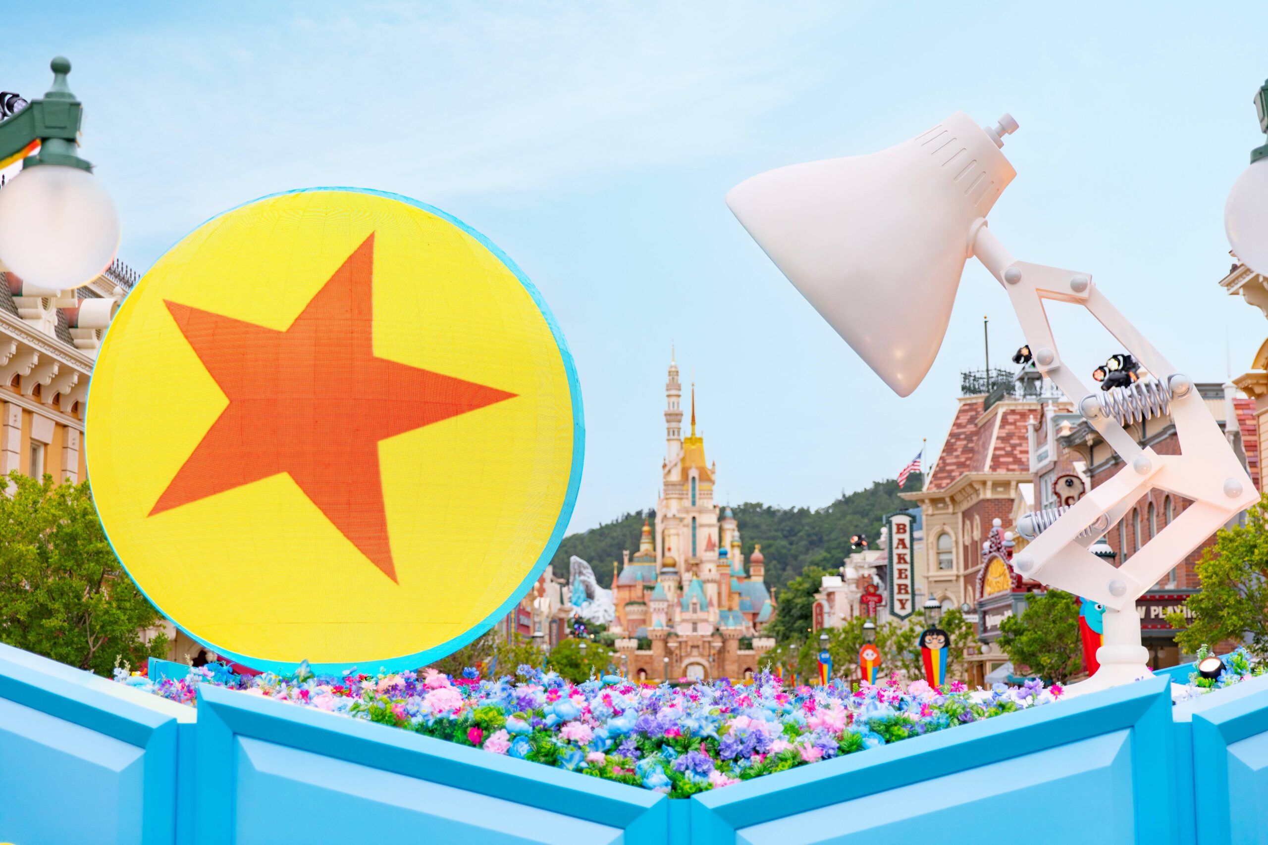 Inside the park, guests will encounter the giant Luxo Jr. lamp and Pixar ball. The lamp shines on the ball, both sitting in a flowerbed of colorful plants.