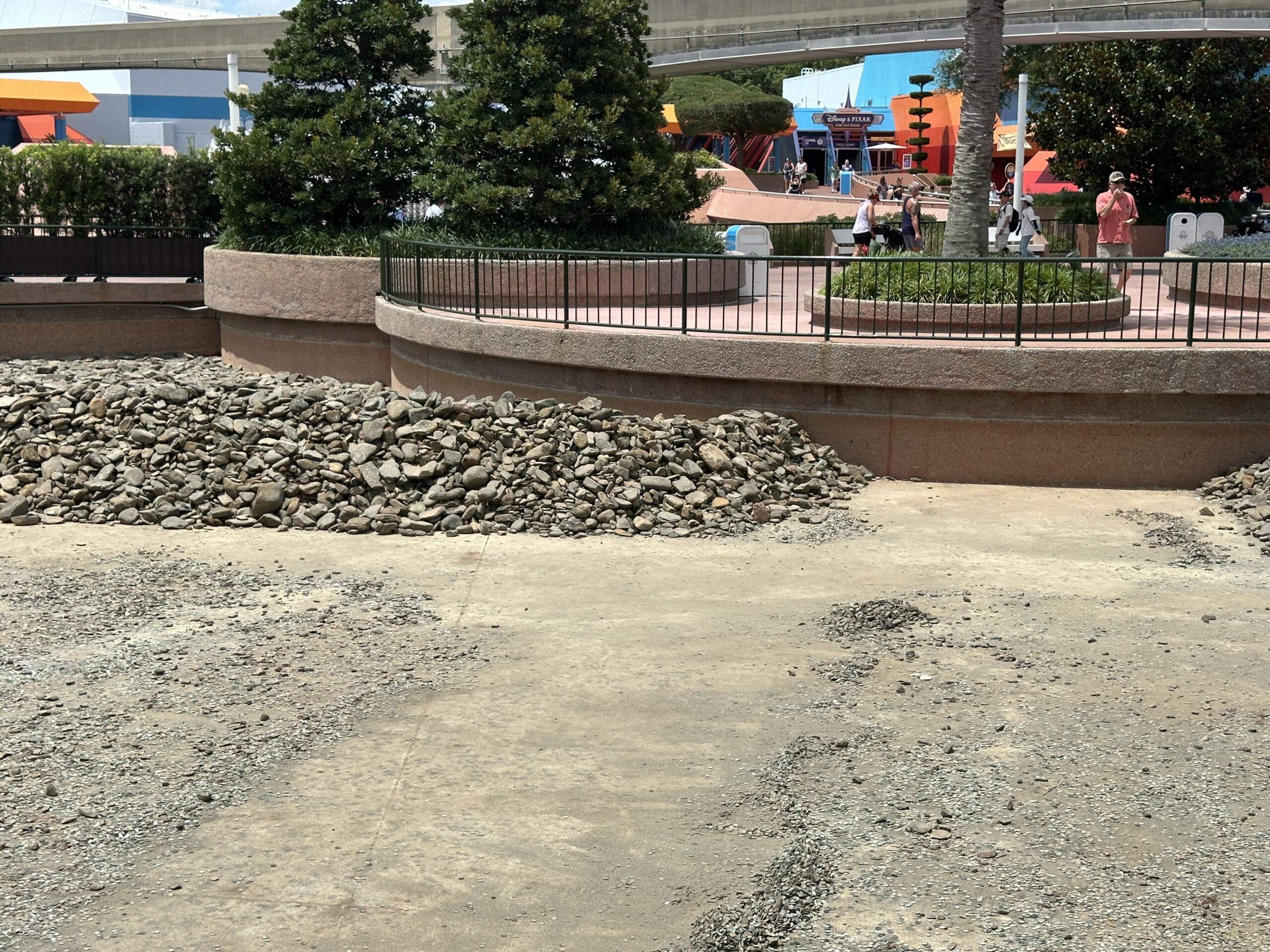 Disney has begun its refurbishment of a World Celebration waterway by draining the water. River rocks have been removed and piled together in certain areas.