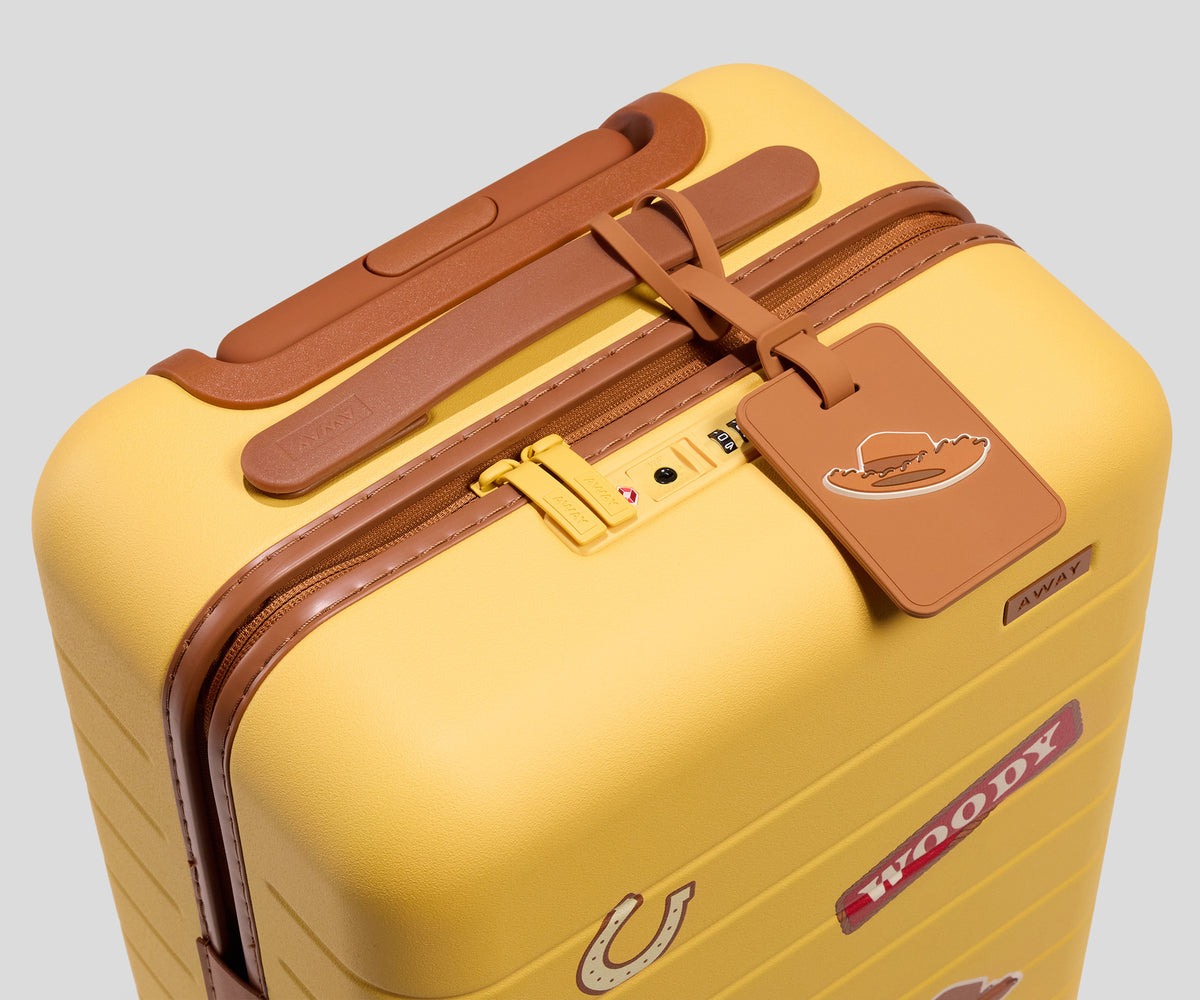 Getting smaller, The Kids Carry On is 19.1" x 12.8" x 8.9" with a capacity of 26 L. They feature the same color schemes but with fun graphics on the sides. The Woody suitcase features a full-body image of Woody, his name, a horseshoe, and his hat.