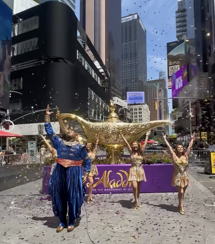 As part of the celebratory unveiling in Times Square, several current cast members performed "Friend Like Me" from the musical. This included Caleb A. Barnett as Genie as well as ensemble members Keisha Gilles, Mikayla Renfrow, Anju Cloud, and Adriana Negron. Bernett recently stepped into the role on May 5 after the departure of the longest-running Genie, Michael James Scott.