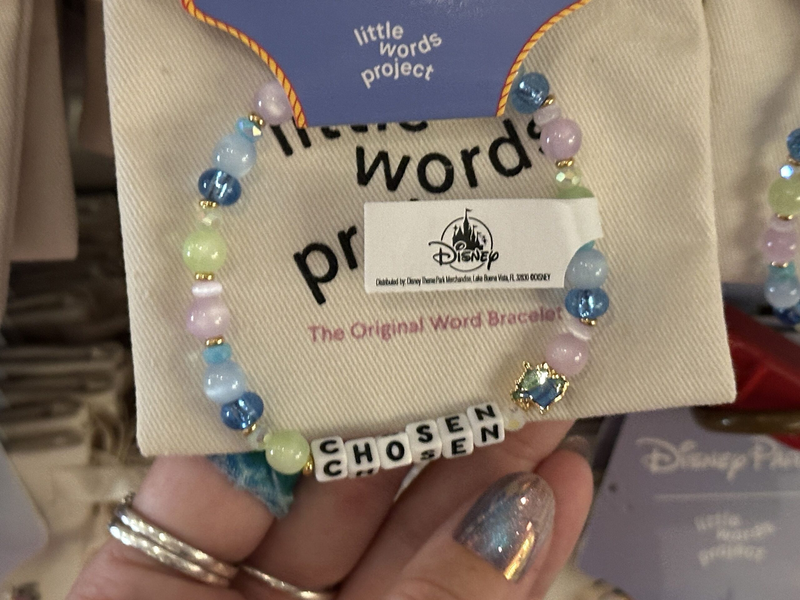 Feel chosen with this Little Green Alien-inspired bracelet. It has glittery blue, green, and purple beads plus a full-body charm of an alien.