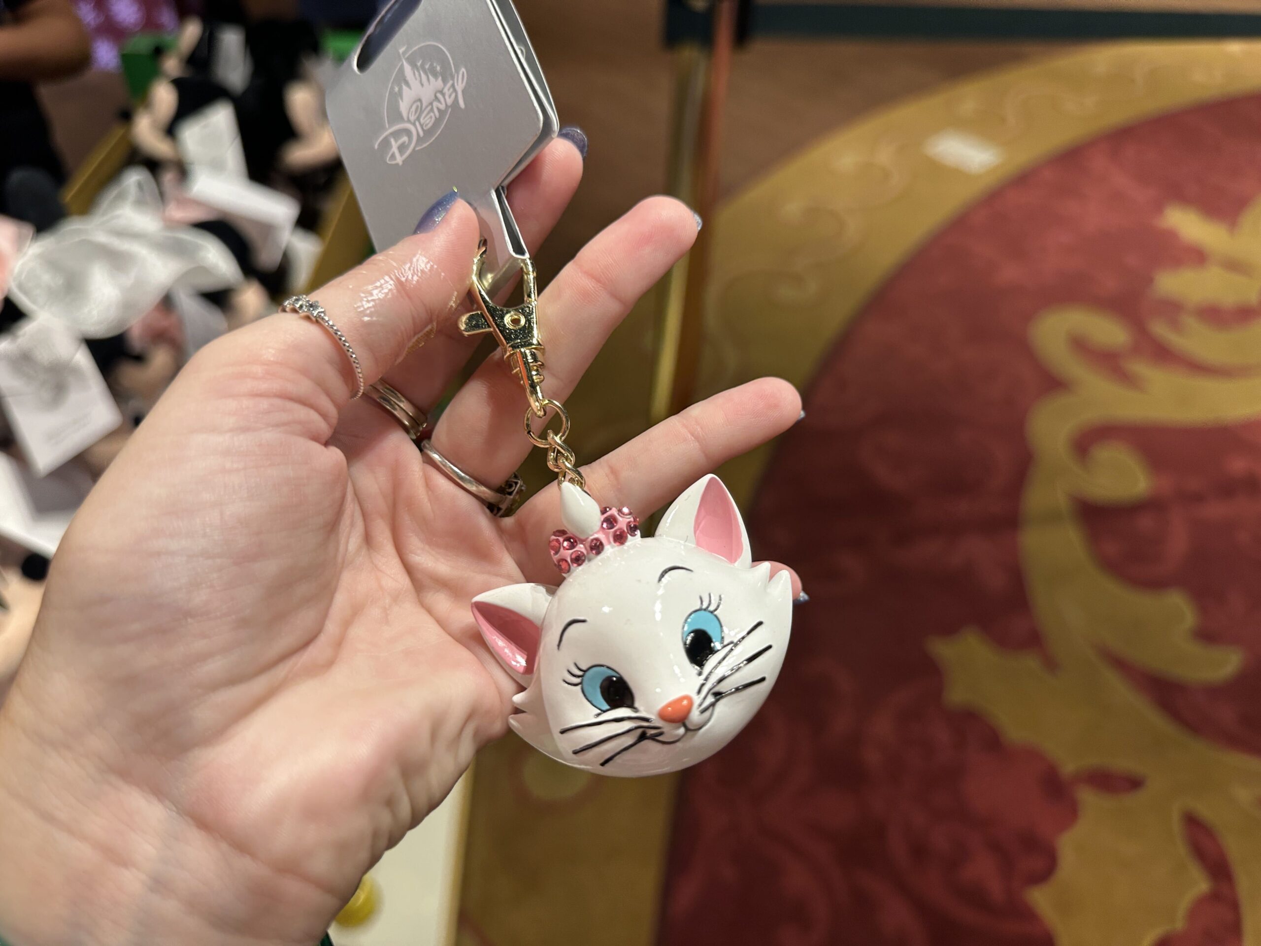 Finally, Marie, the cat, is depicted on this keychain. She has a small pink bow on top that is studded with darker pink gems.