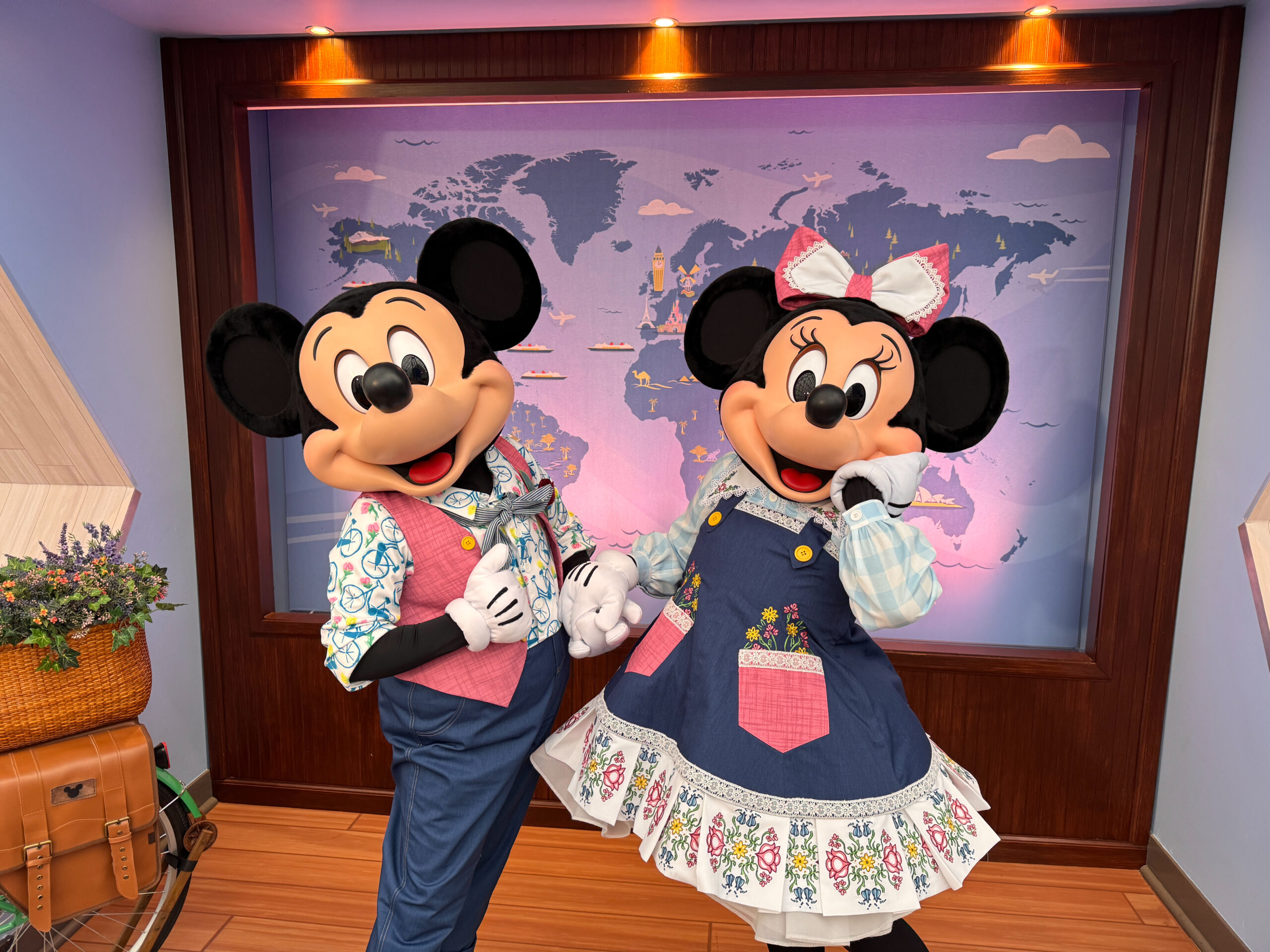 Minnie wears a blue jumper over a light blue shirt. The jumper has a pink pocket and a floral and lace trim. Her pink bow matches the pocket.