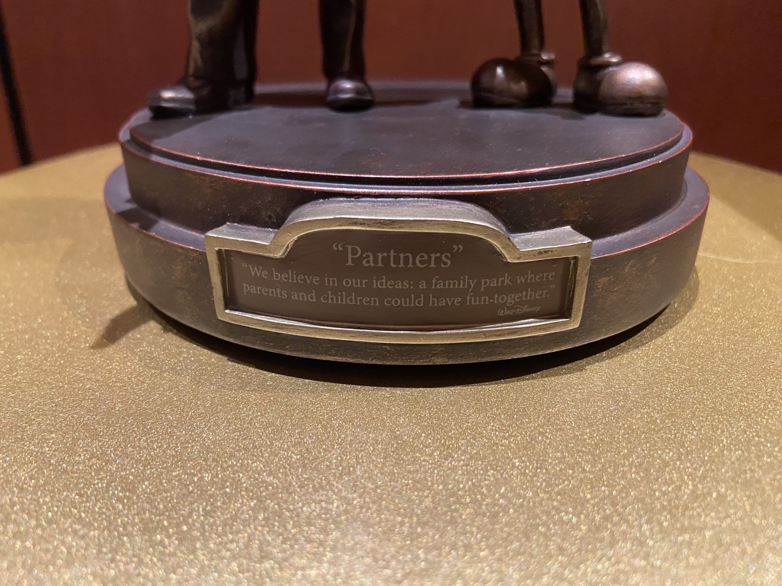 A placard on the front of the statue indicates its name, “Parters,” as well as the quote from Walt Disney seen on the front of the statue at Magic Kingdom: “We believe in our ideas: a family park where parents and children could have fun together.”
