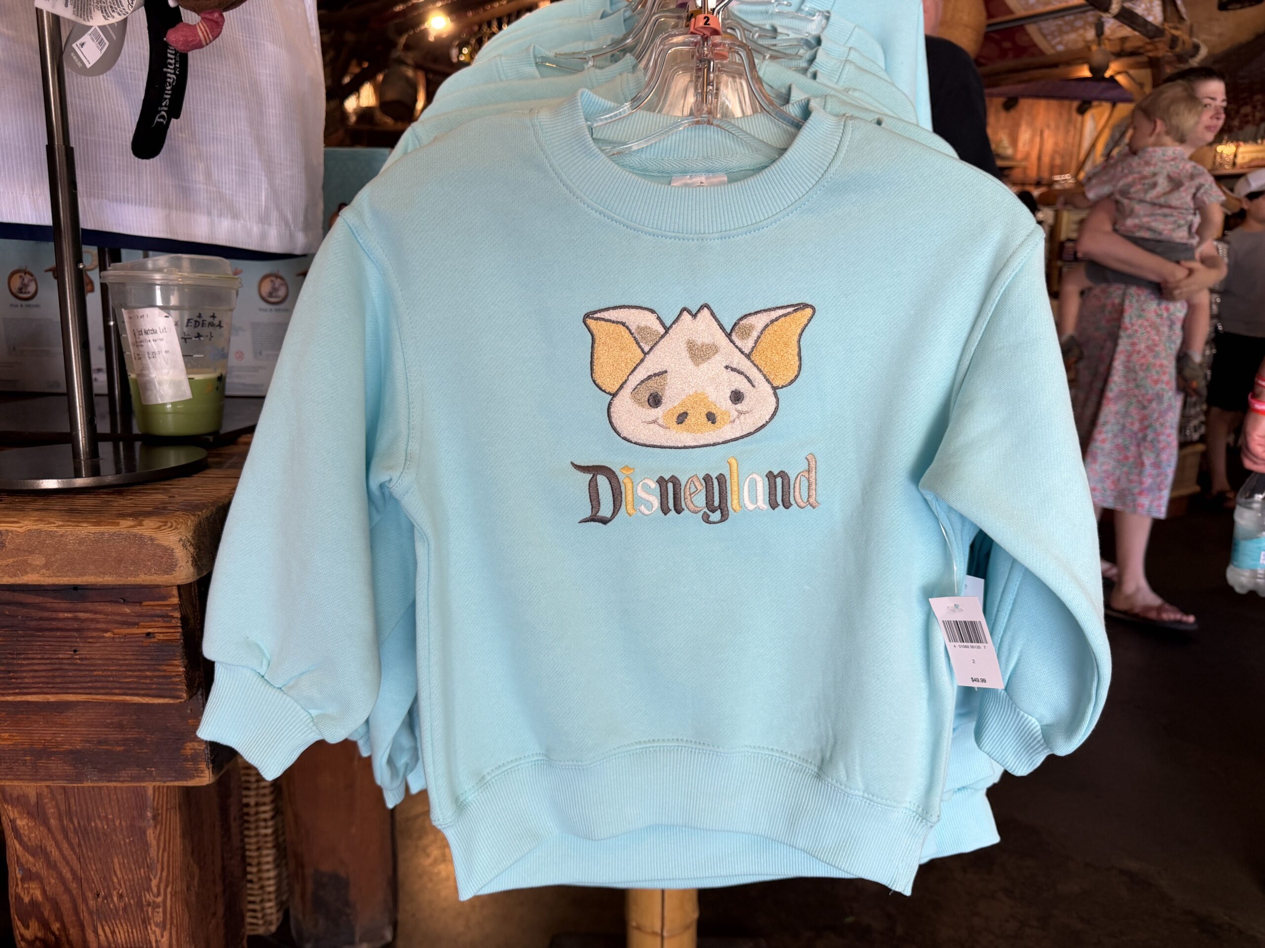 Pua's face is front and center on this robin egg blue pullover sweatshirt. "Disneyland" is shown below in various colors.