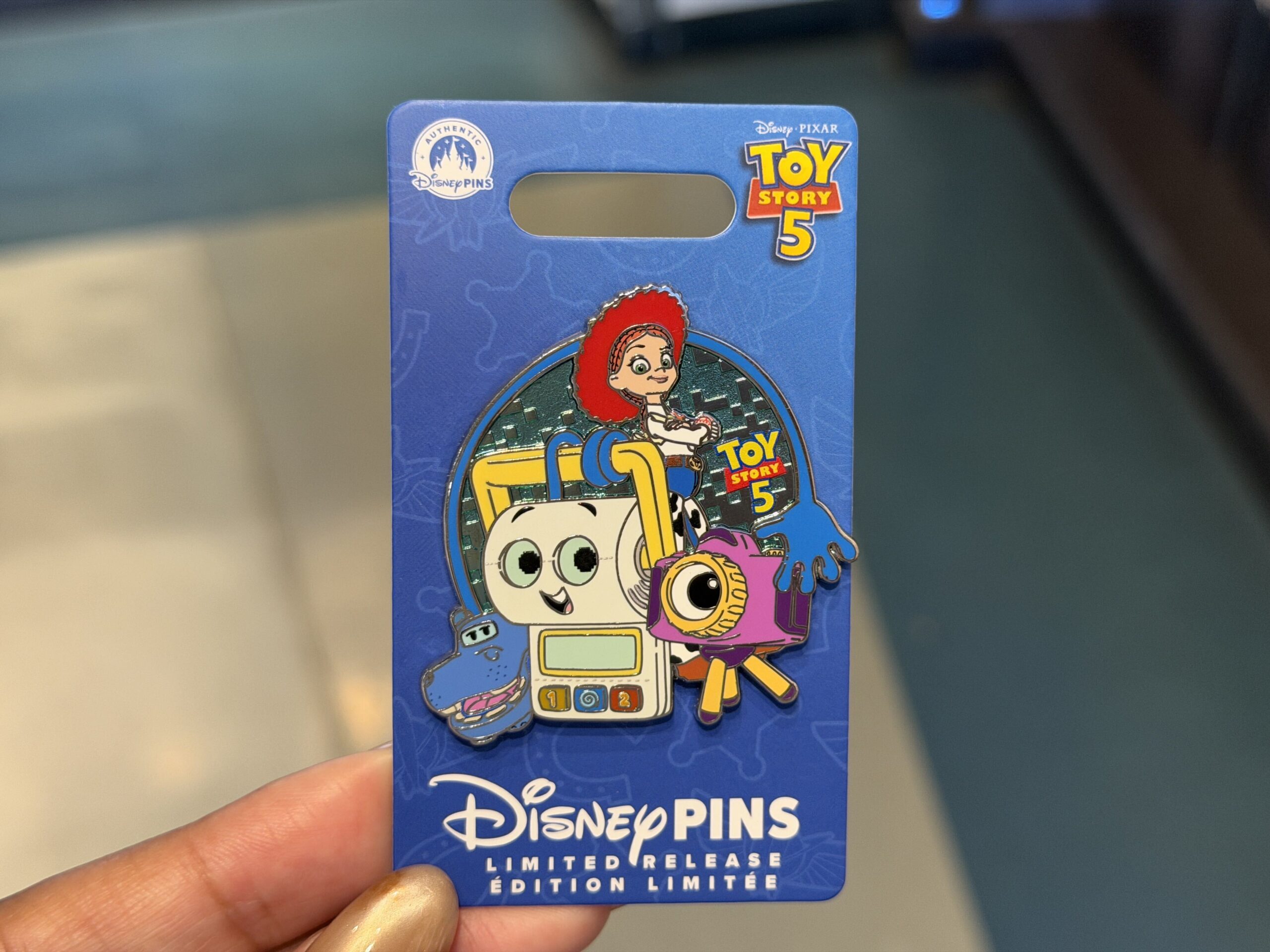 Another Toy Story 5 pin features Jessie and three of the film's new characters: Atlas the GPS hippo, Smarty Pants the toilet training toy, and Snappy the toy camera.