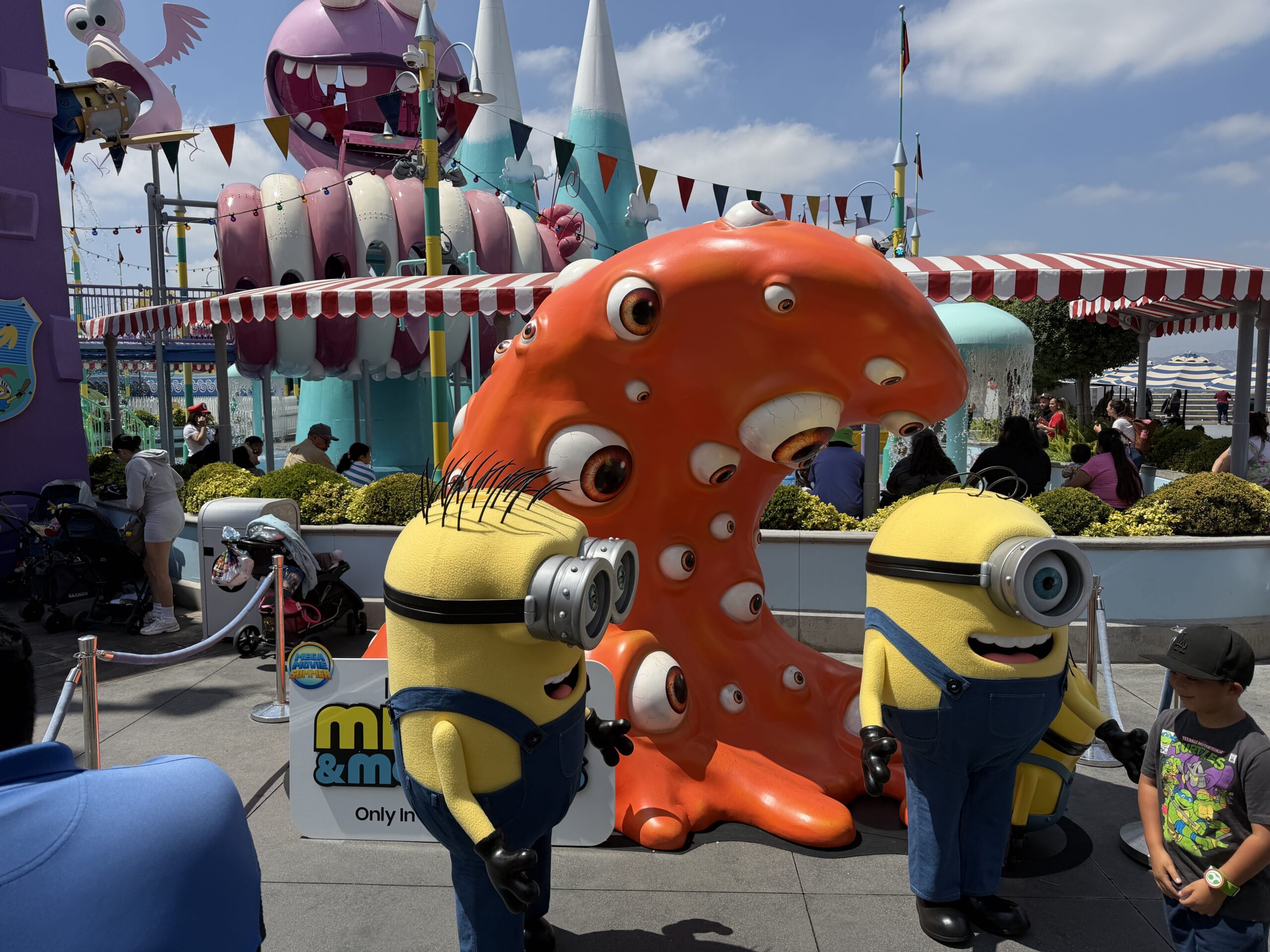 Henry and James are protagonist Minions from the upcoming Minions & Monsters movie. They are both now available for guests to meet at Universal Studios Hollywood. Behind them is a standee of Irene, another new character in the upcoming film.