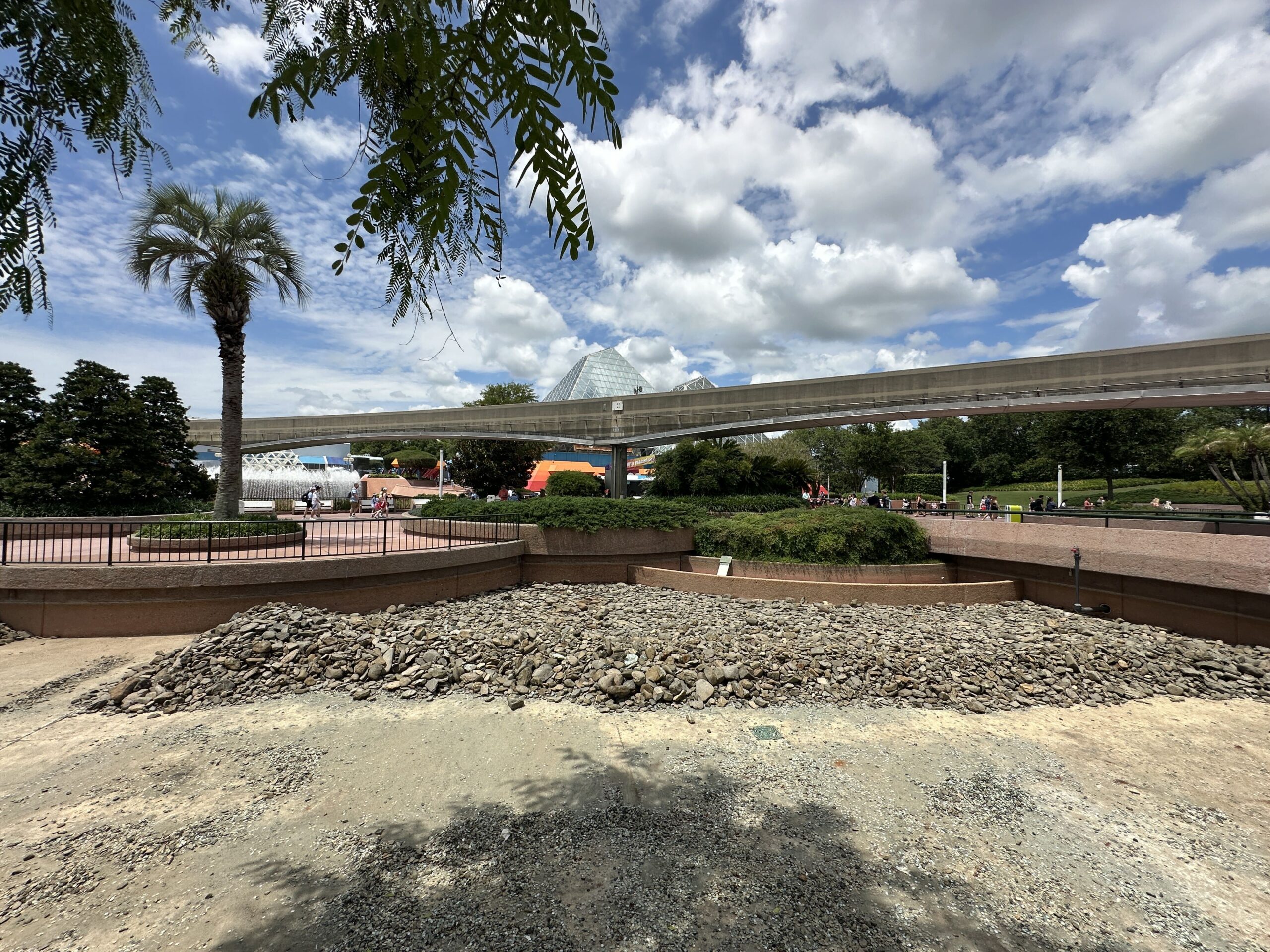 Disney has begun its refurbishment of a World Celebration waterway by draining the water. River rocks have been removed and piled together in certain areas.