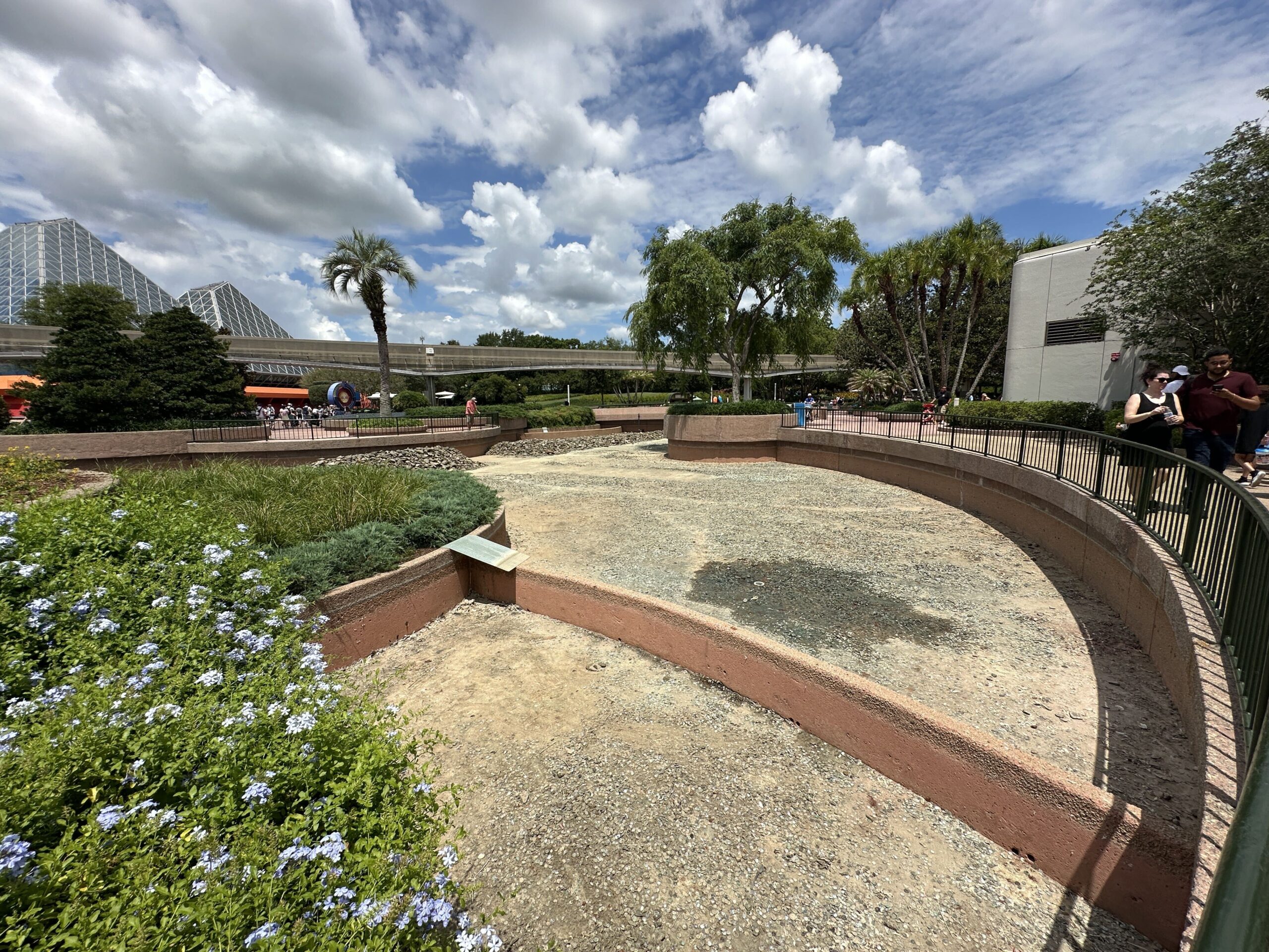 Disney has begun its refurbishment of a World Celebration waterway by draining the water. River rocks have been removed and piled together in certain areas.