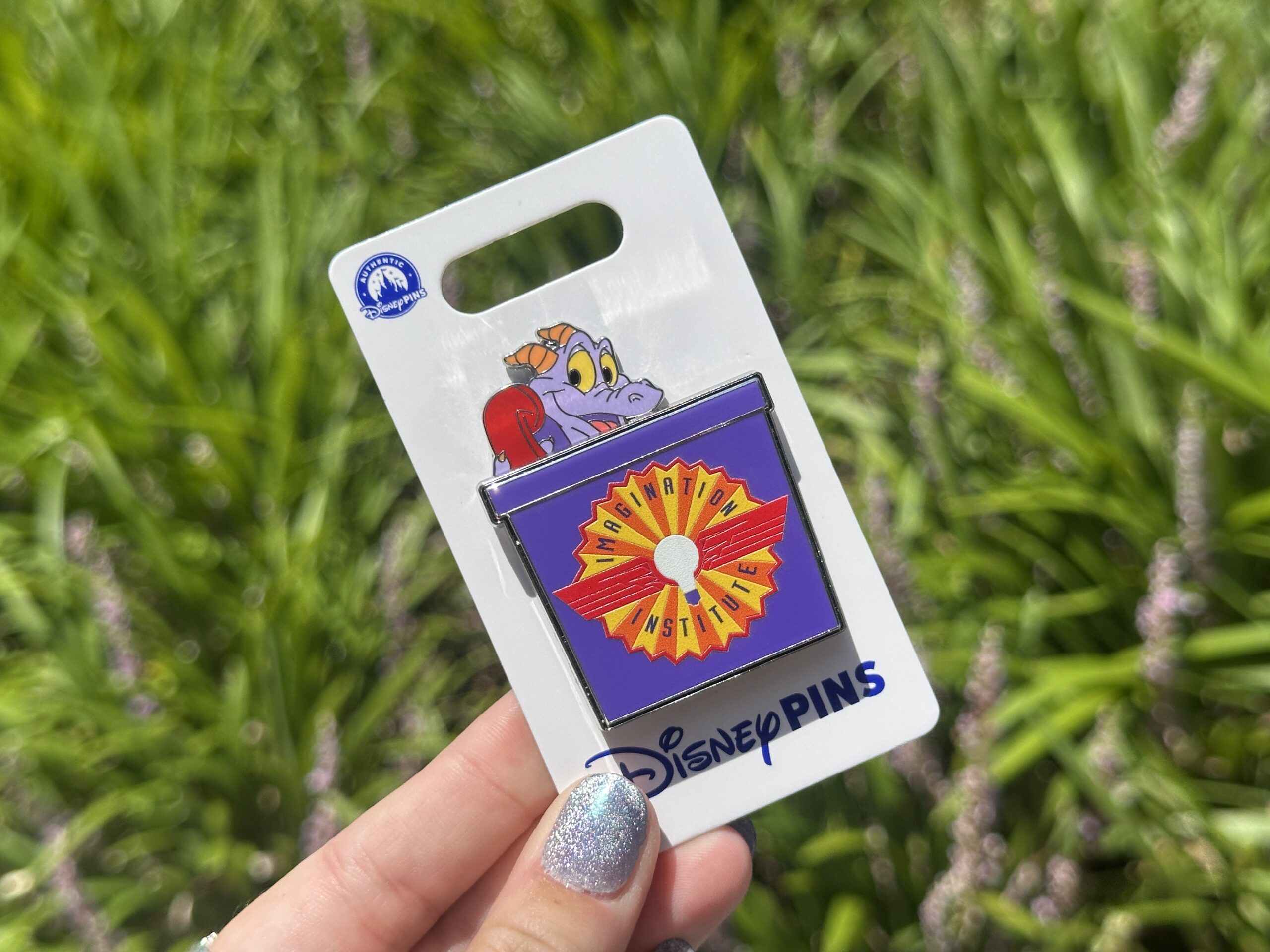 Inspired by the sound scene of Journey Into Imagination With Figment, this pin features Figment in his yellow sweater talking on a red phone. He pops out of a purple box featuring the Imagination Institute logo.