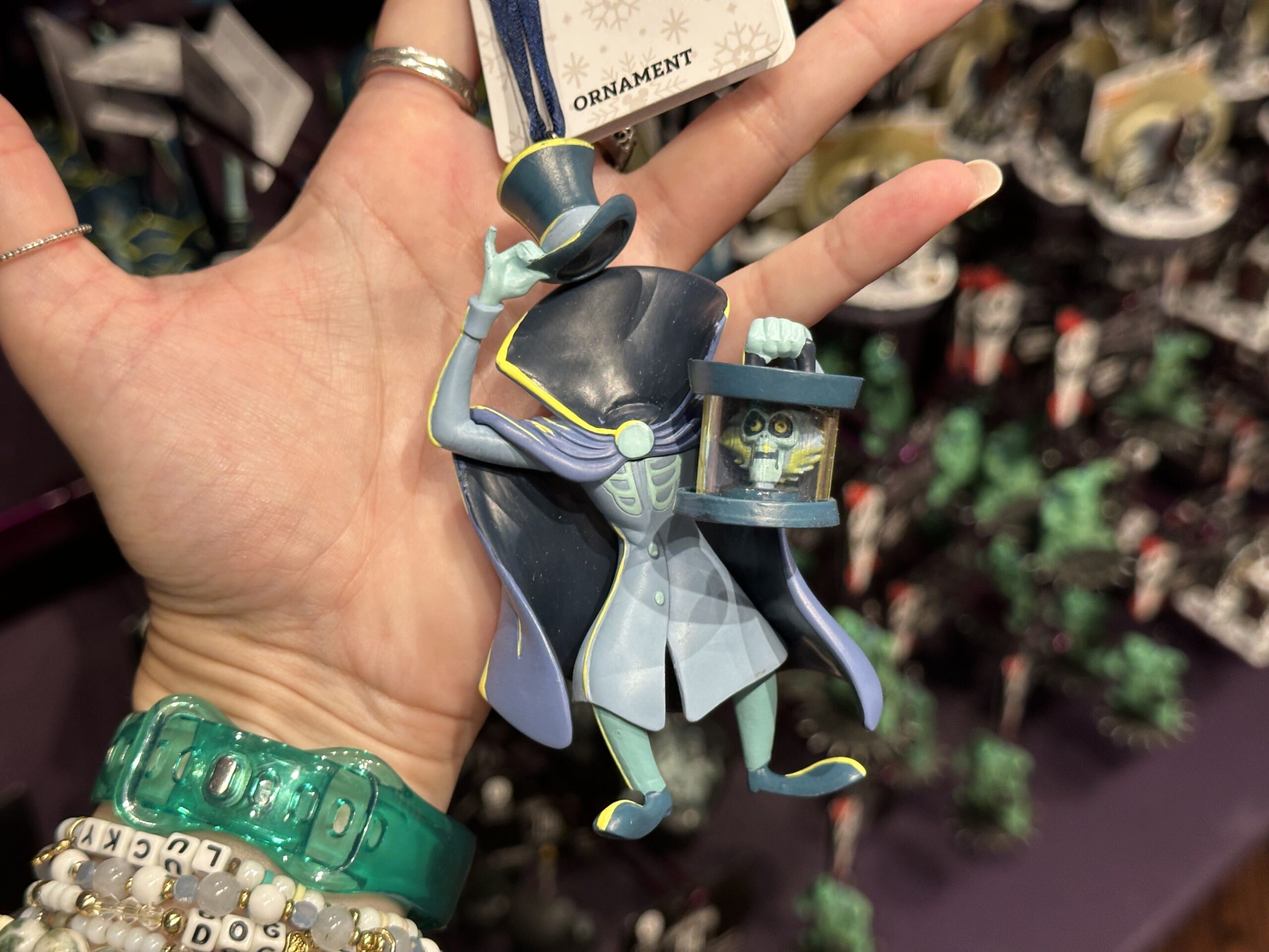 Inspired by the nefarious Hatbox Ghost, this sculpted ornament figure depicts the ghost's head in his hatbox. His tall collar, by contrast, is empty with one hand holding up his top hat.
