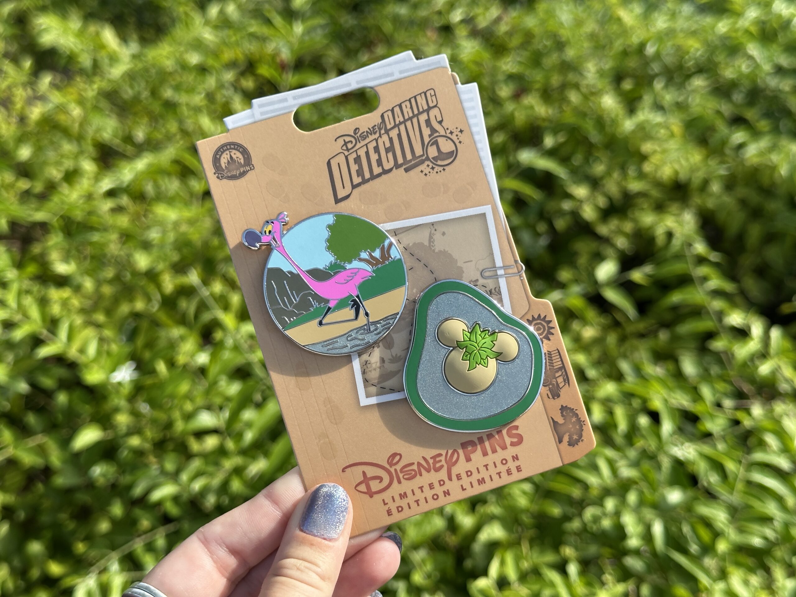This week's "Daring Detectives" series features Disney's Animal Kingdom locations. This first pin set is inspired by the Mickey-shaped flamingo island on Kilimanjaro Safaris. One pin depicts a flamingo while the other is the island.