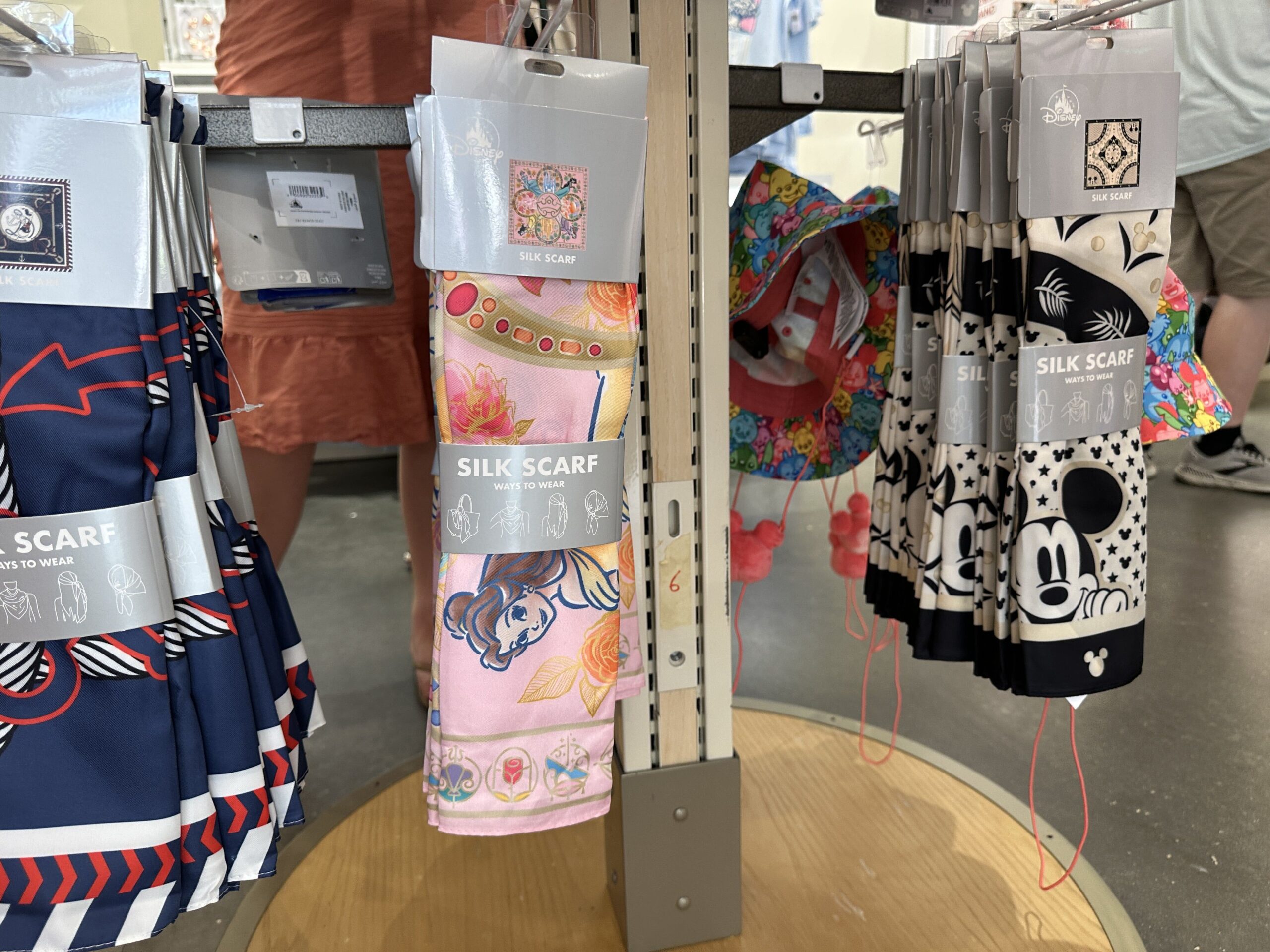 The silk scarf is folded up and comes in gray packaging that shows the full design as well as potential ways to wear the scarf.