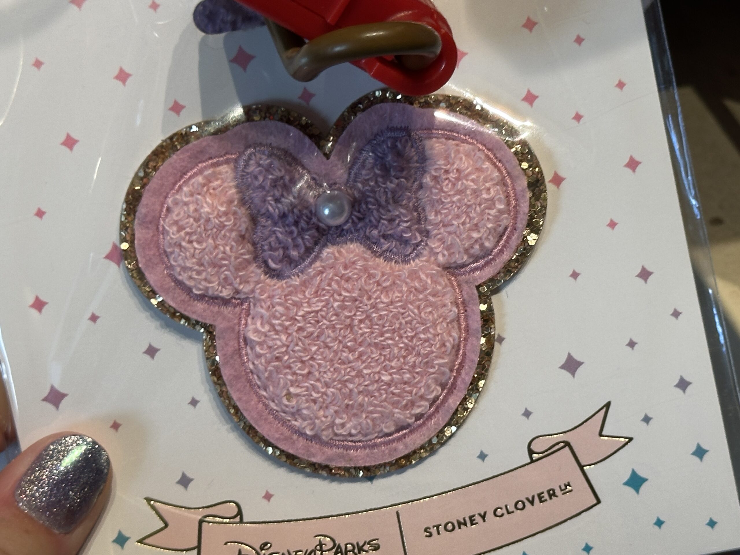 This Minnie shaped patch is pink with a purple bow and pearl.