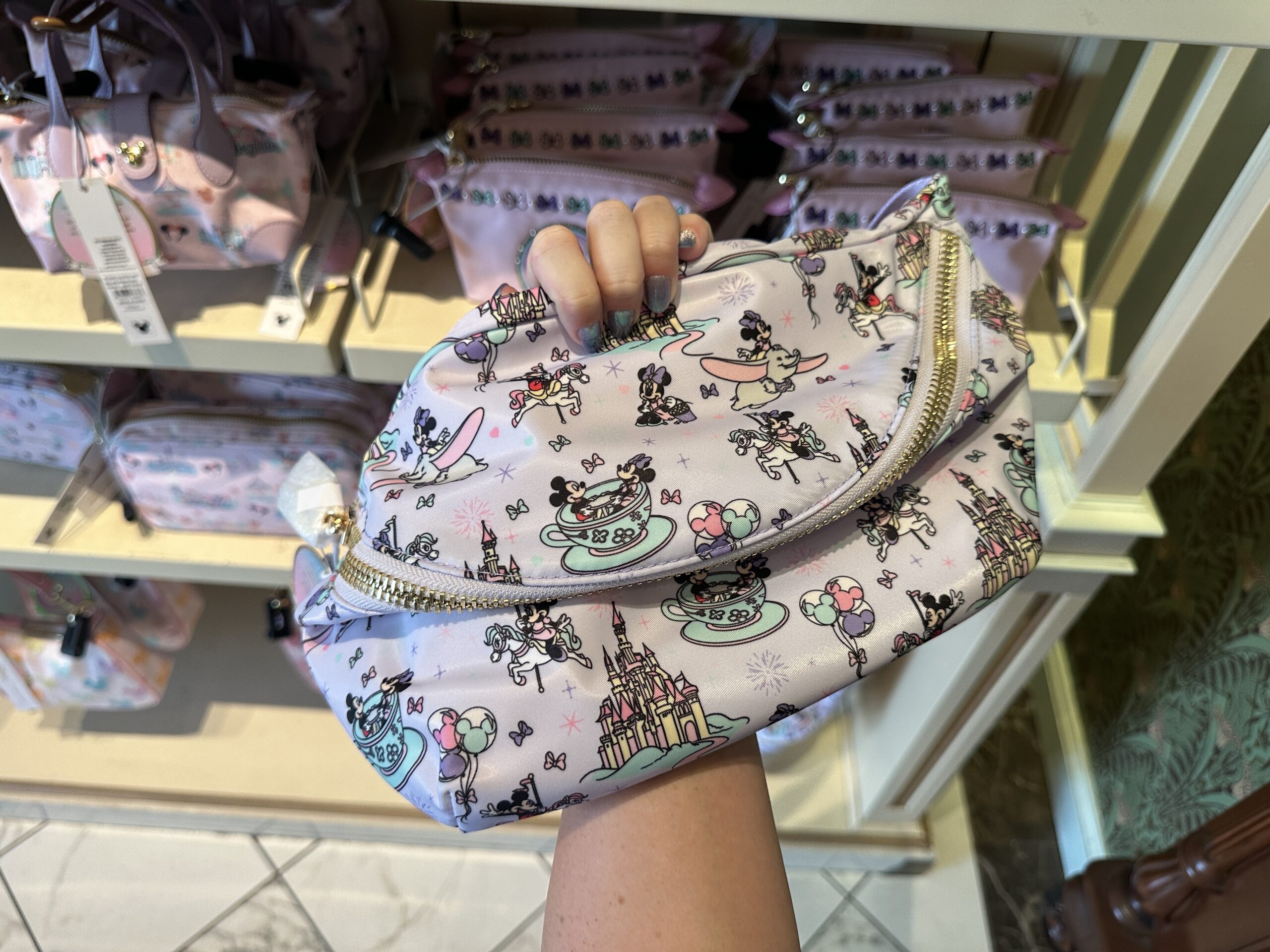 The matching belt bag is light purple with an all-over pattern of Mickey and Minnie in Fantasyland.