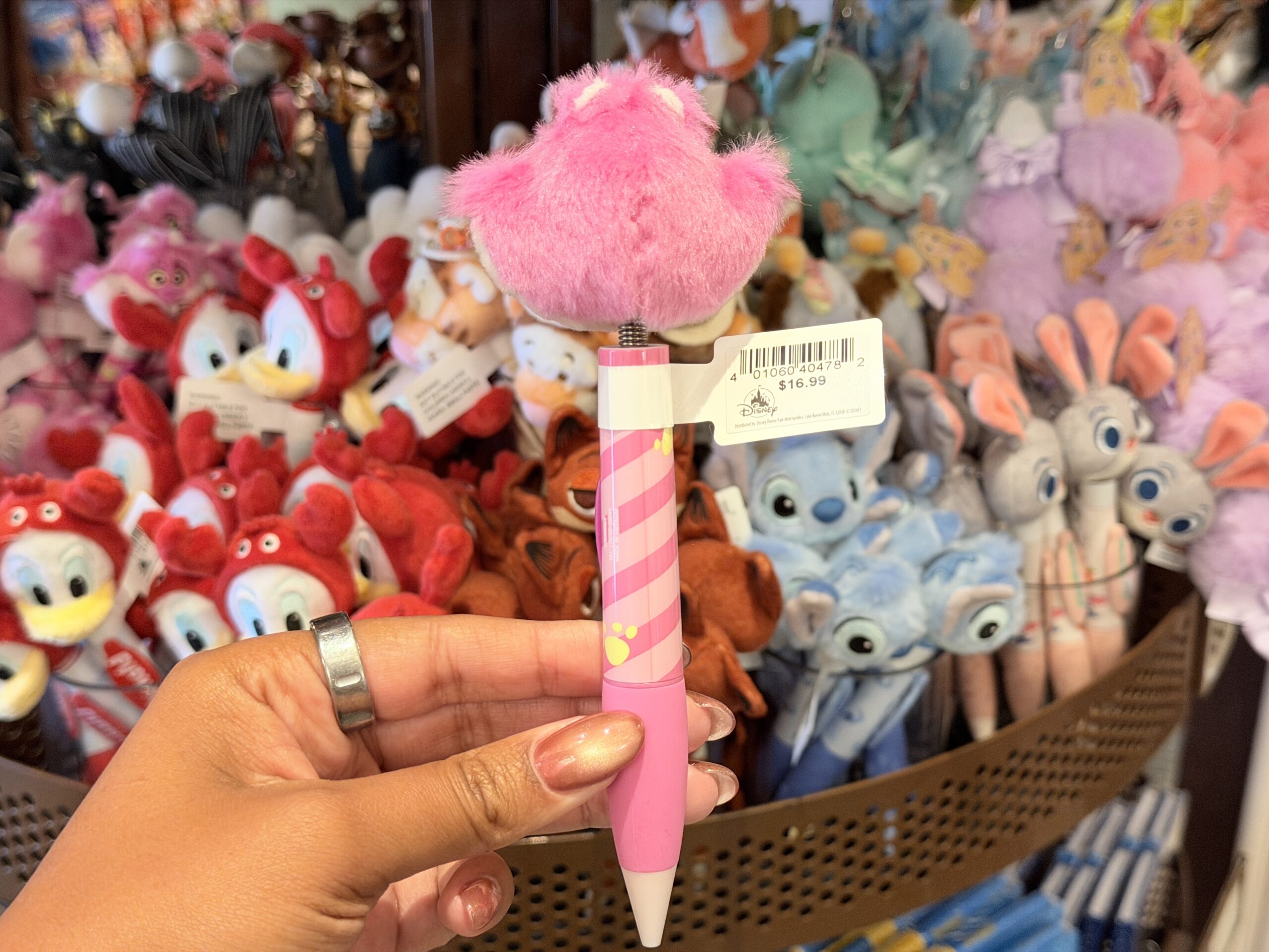 The barrel continues the pink theme with striped artwork and a darker pink nameplate reading “Cheshire Cat.” The pen has a light pink lower section and white tip.