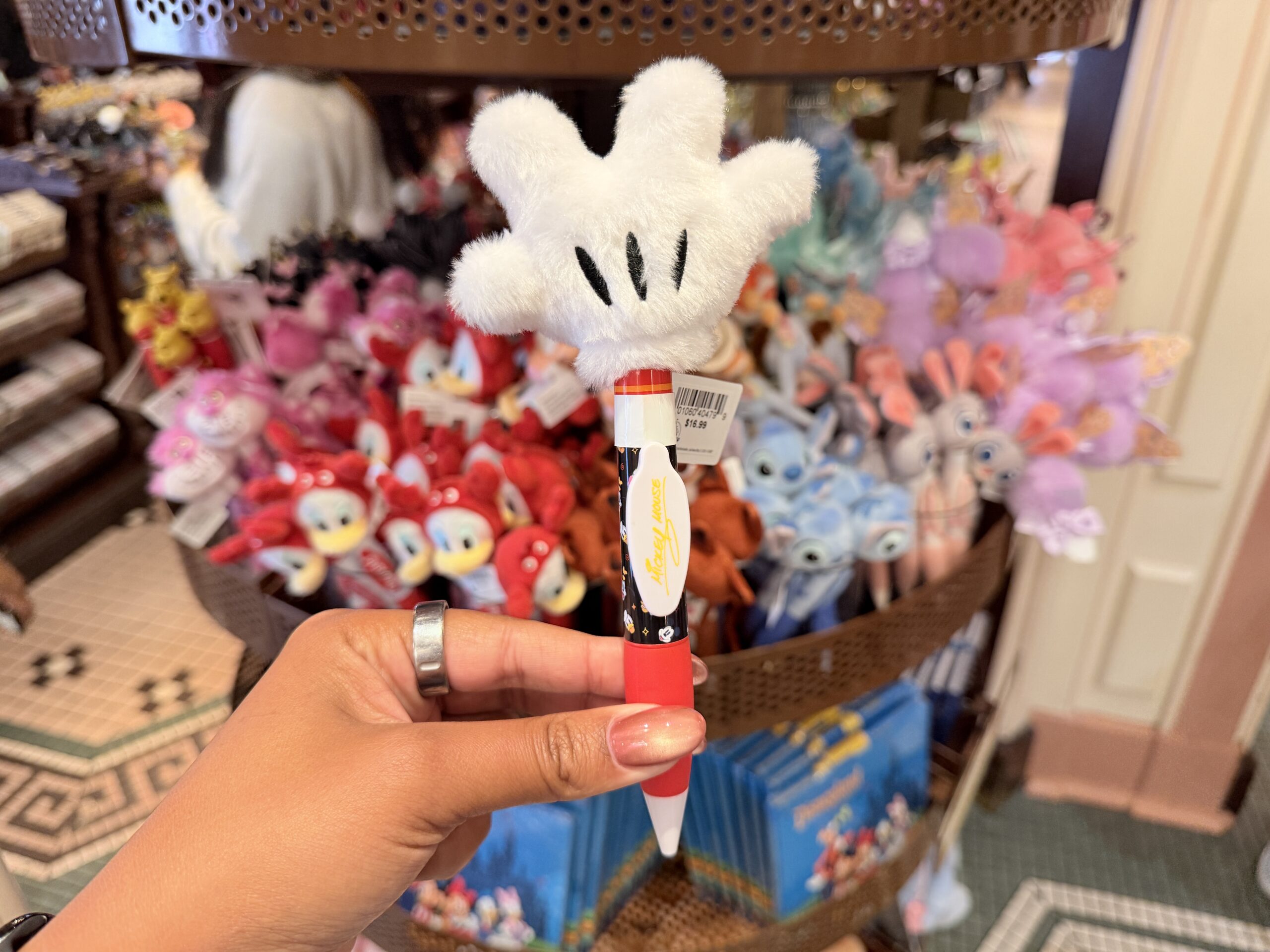 The Mickey glove pen is topped with a plush version of Mickey’s white glove. The glove features the familiar black stitched lines across the palm.