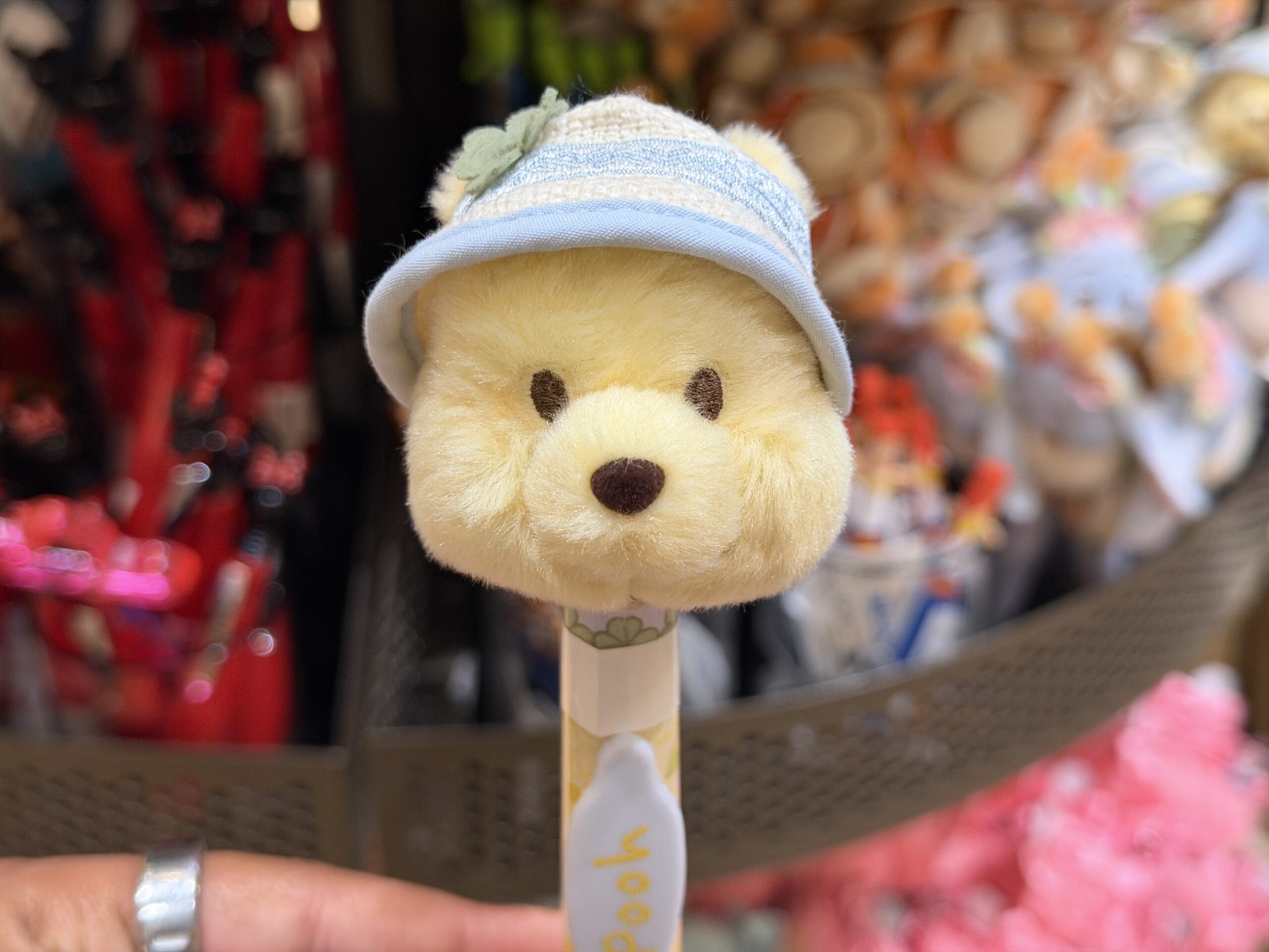 The pen barrel features yellow floral artwork, with a white oval nameplate reading “Pooh” in yellow lettering. The pen tip is yellow, matching Pooh’s color scheme.