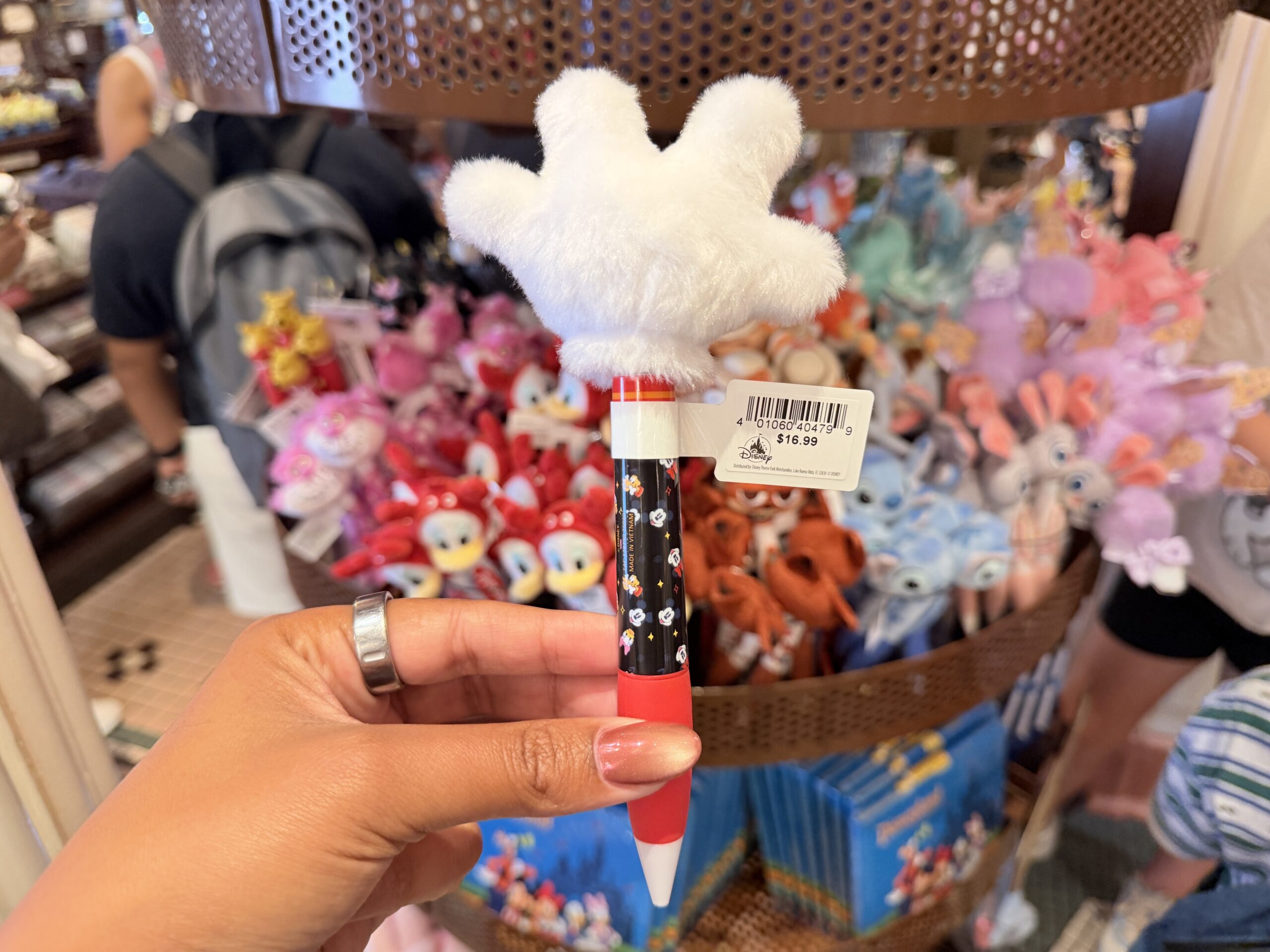 The barrel is red, black, and white, with small Mickey icon artwork and a white nameplate reading “Mickey Mouse” in yellow script. The red lower barrel and white pen tip give it a classic Mickey-inspired color scheme.