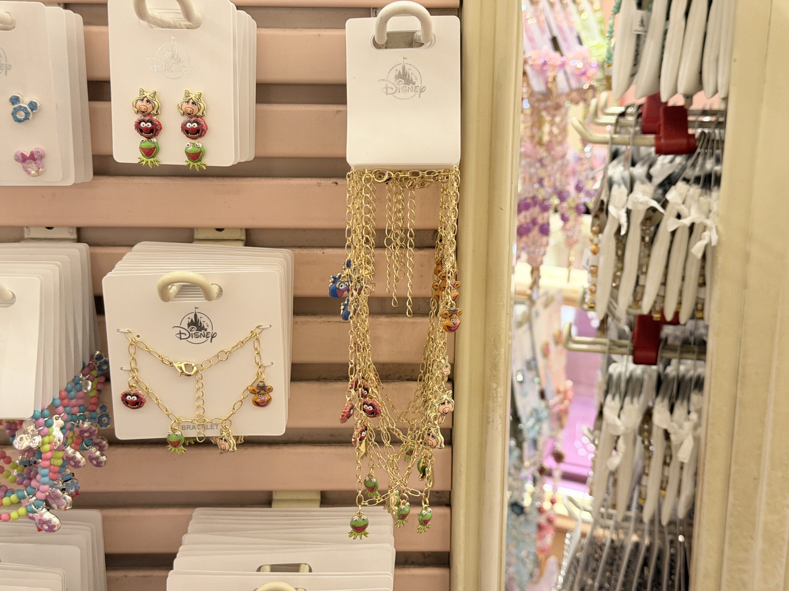 The necklace has a gold-tone chain and features several dangling charms of Muppets characters.