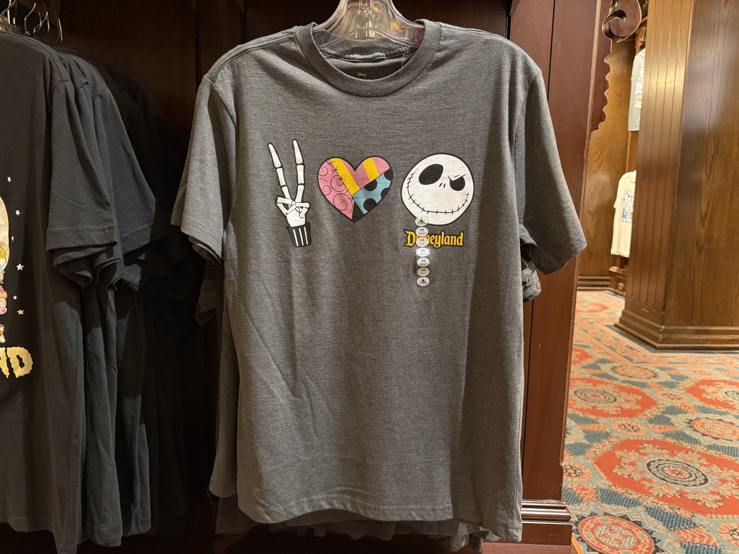 This gray shirt symbolizes peace, love, and Jack Skellington. Jack's fingers make the peace sign, the heart is filled with a Sally-inspired pattern, and Jack's face is on the end.