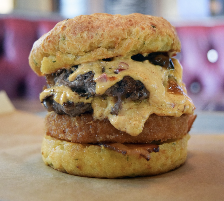 This specialty, limited-time burger features two pressed beef patties, pimento cheese, fried green tomato, bacon, and jalapaño jam in a cheddar-chive biscuit.