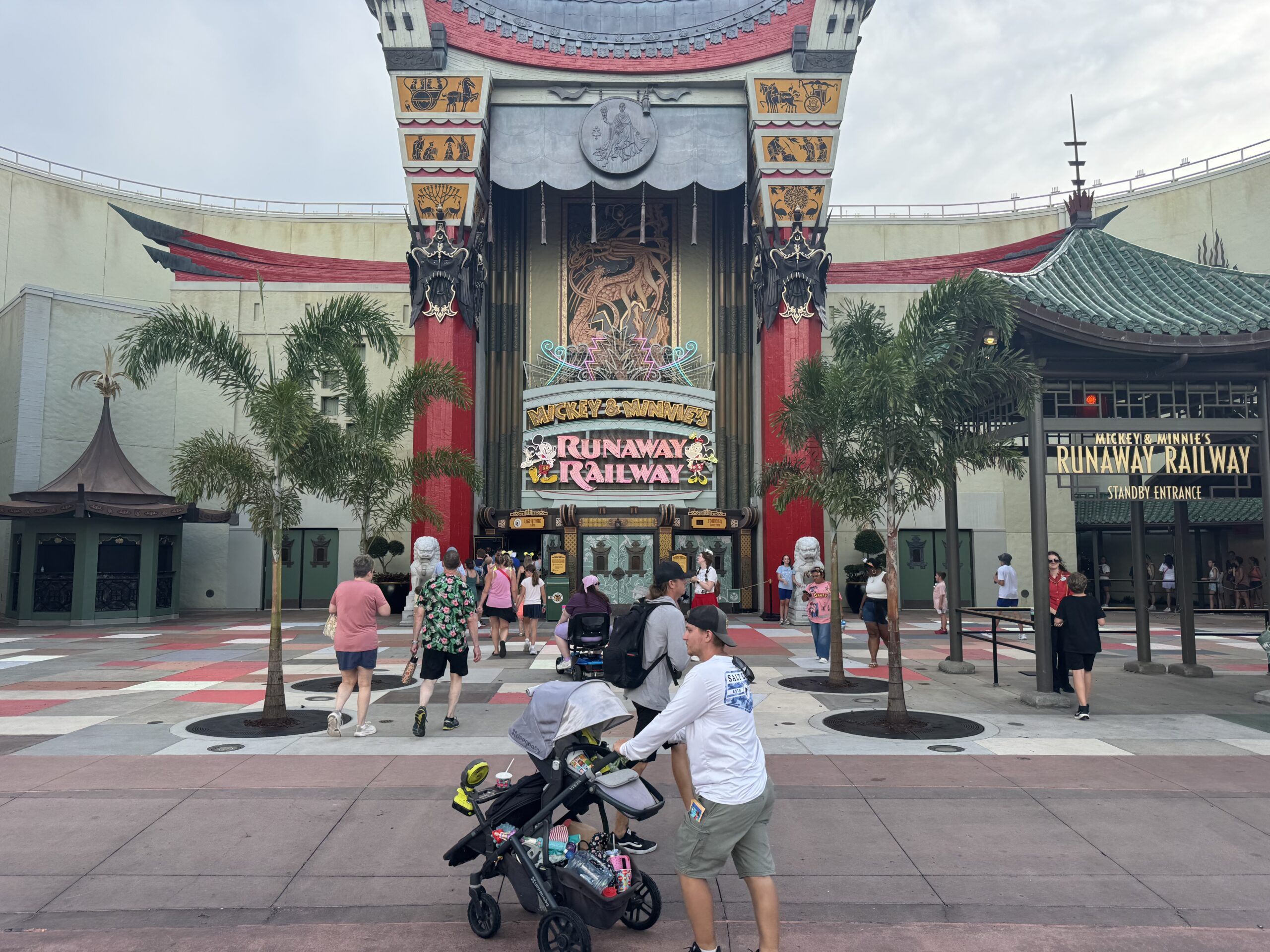 The replacements restore some symmetry to the theater’s forecourt while framing views of the Mickey & Minnie’s Runaway Railway signage. The palms also complement the existing planters, sculpted shrubs, and Chinese guardian lion statues around the entrance.