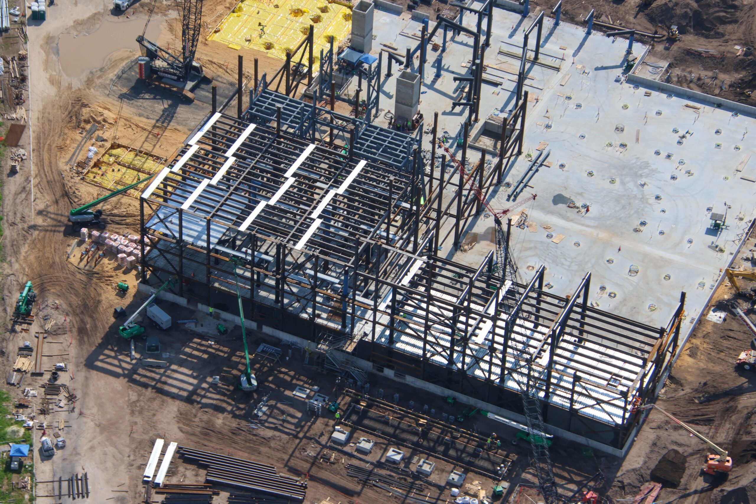 The doors are beginning to fall into place at the upcoming Monsters, Inc. roller coaster, as new aerial photos reveal progress on the attraction’s construction.