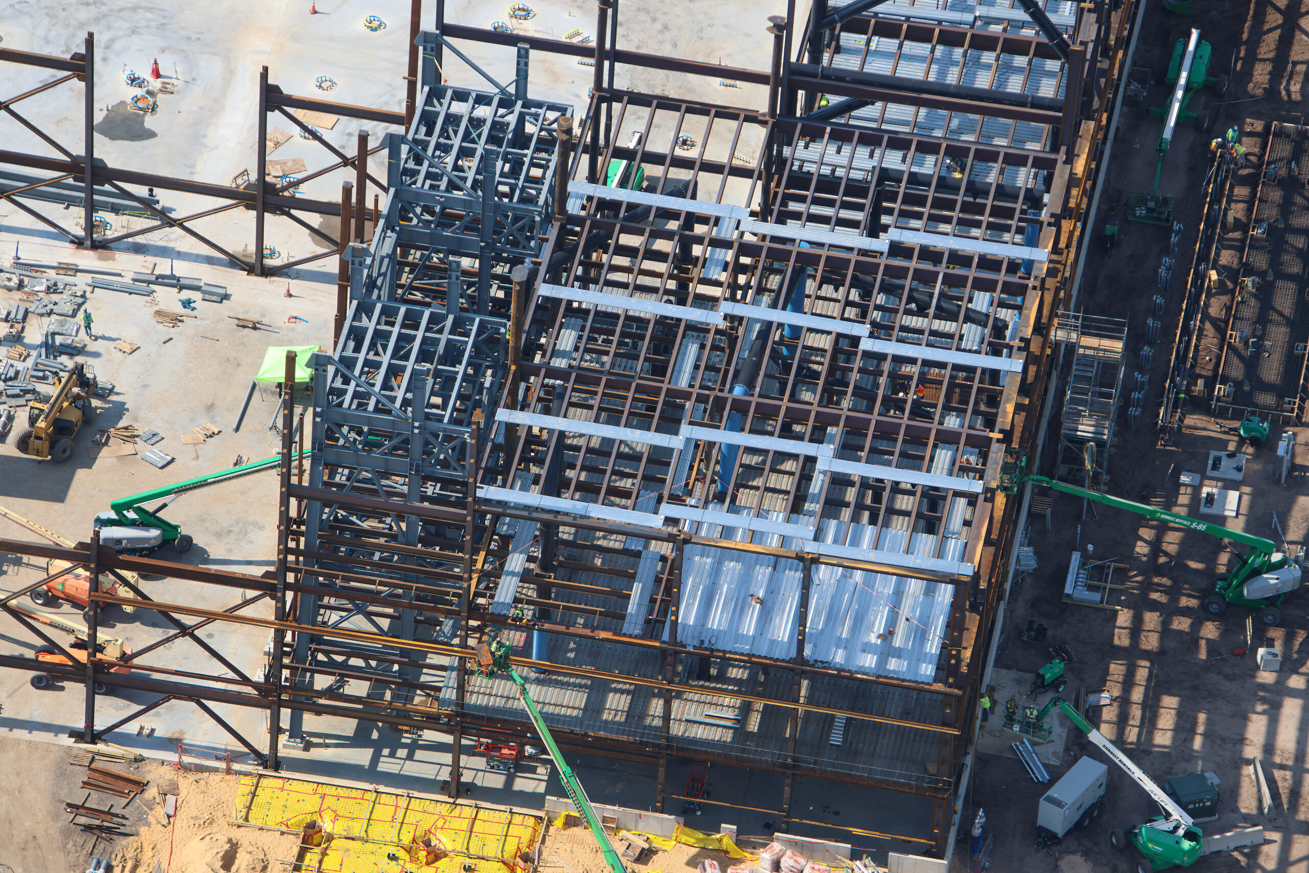 The doors are beginning to fall into place at the upcoming Monsters, Inc. roller coaster, as new aerial photos reveal progress on the attraction’s construction.