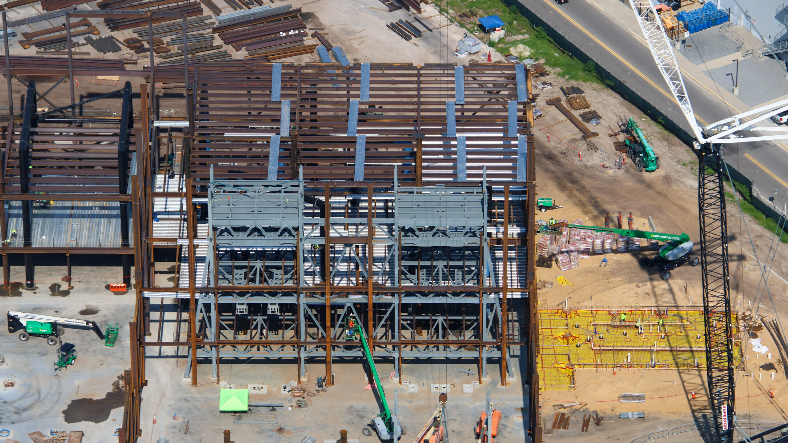The doors are beginning to fall into place at the upcoming Monsters, Inc. roller coaster, as new aerial photos reveal progress on the attraction’s construction.