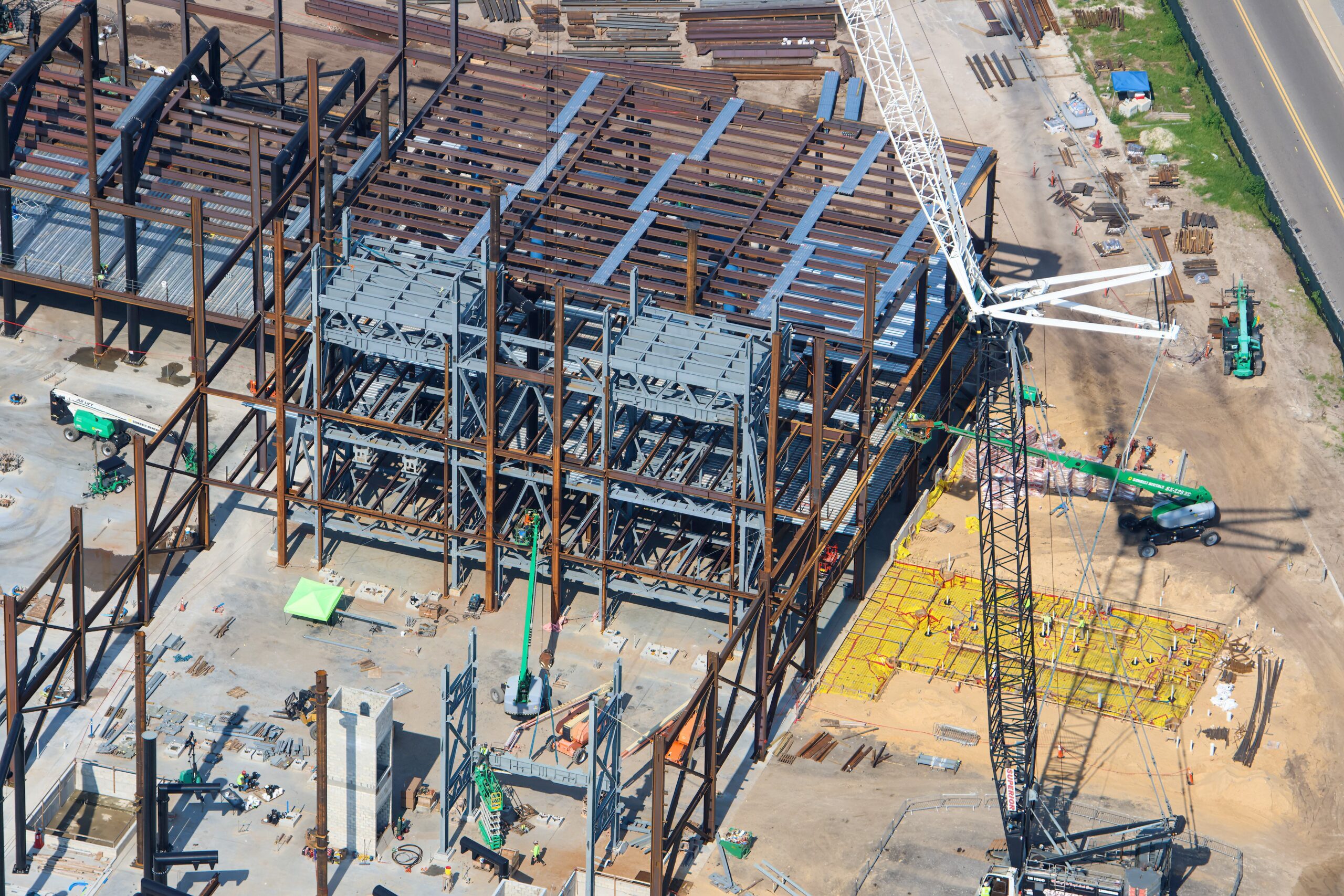 The doors are beginning to fall into place at the upcoming Monsters, Inc. roller coaster, as new aerial photos reveal progress on the attraction’s construction.
